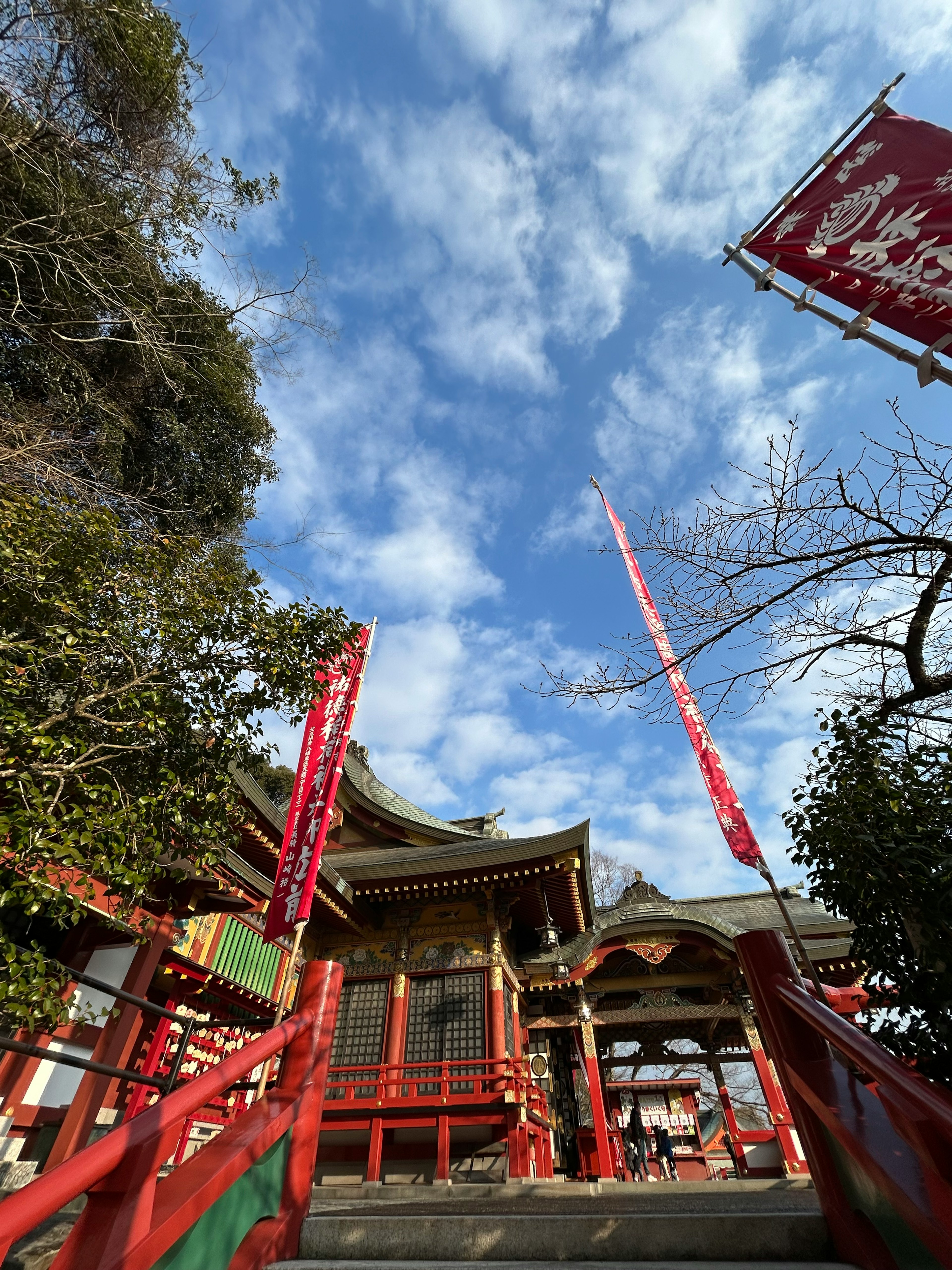 赤い階段と神社の建物が見える青空の風景