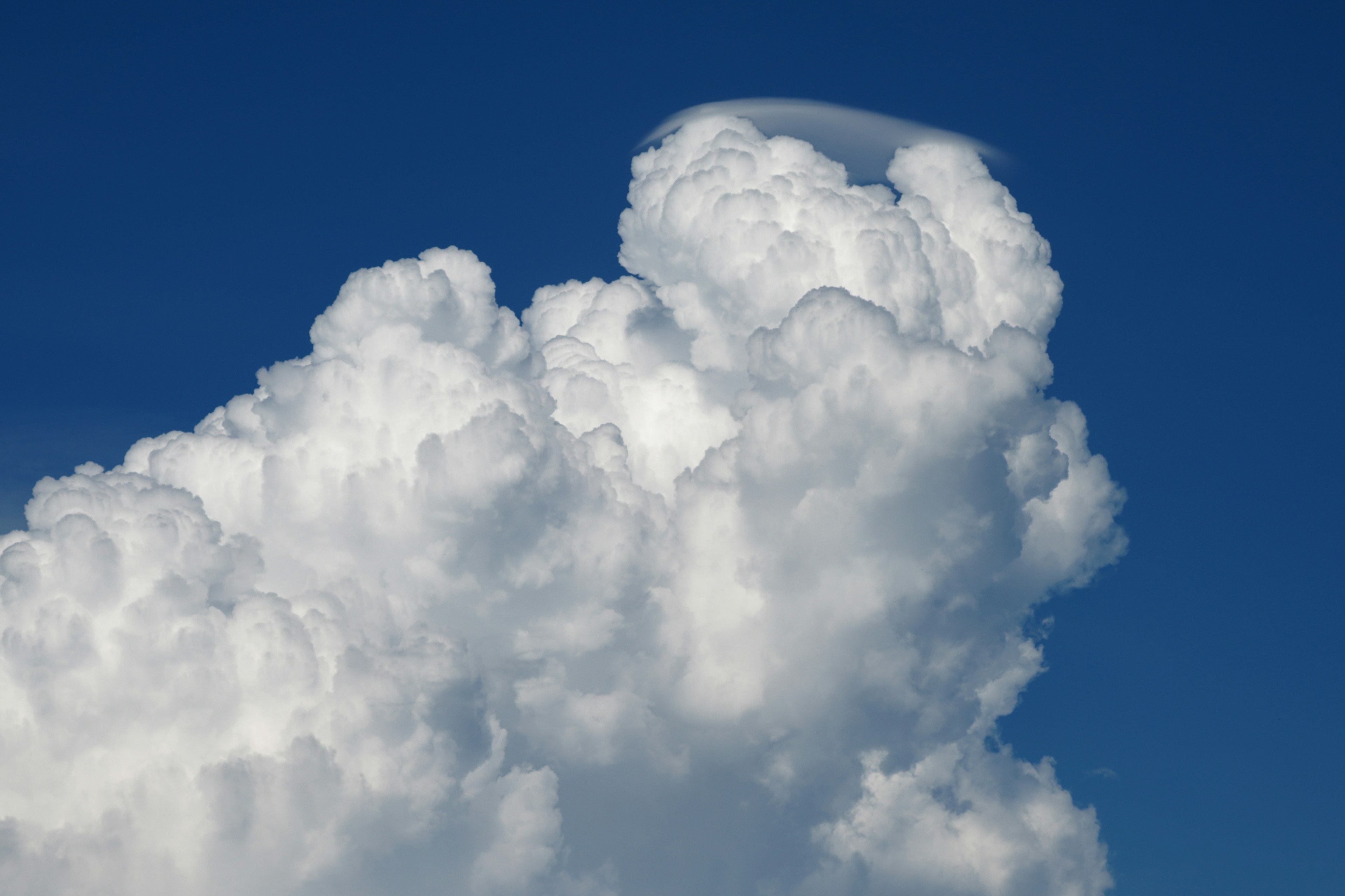 Large white cloud with unique shape against blue sky