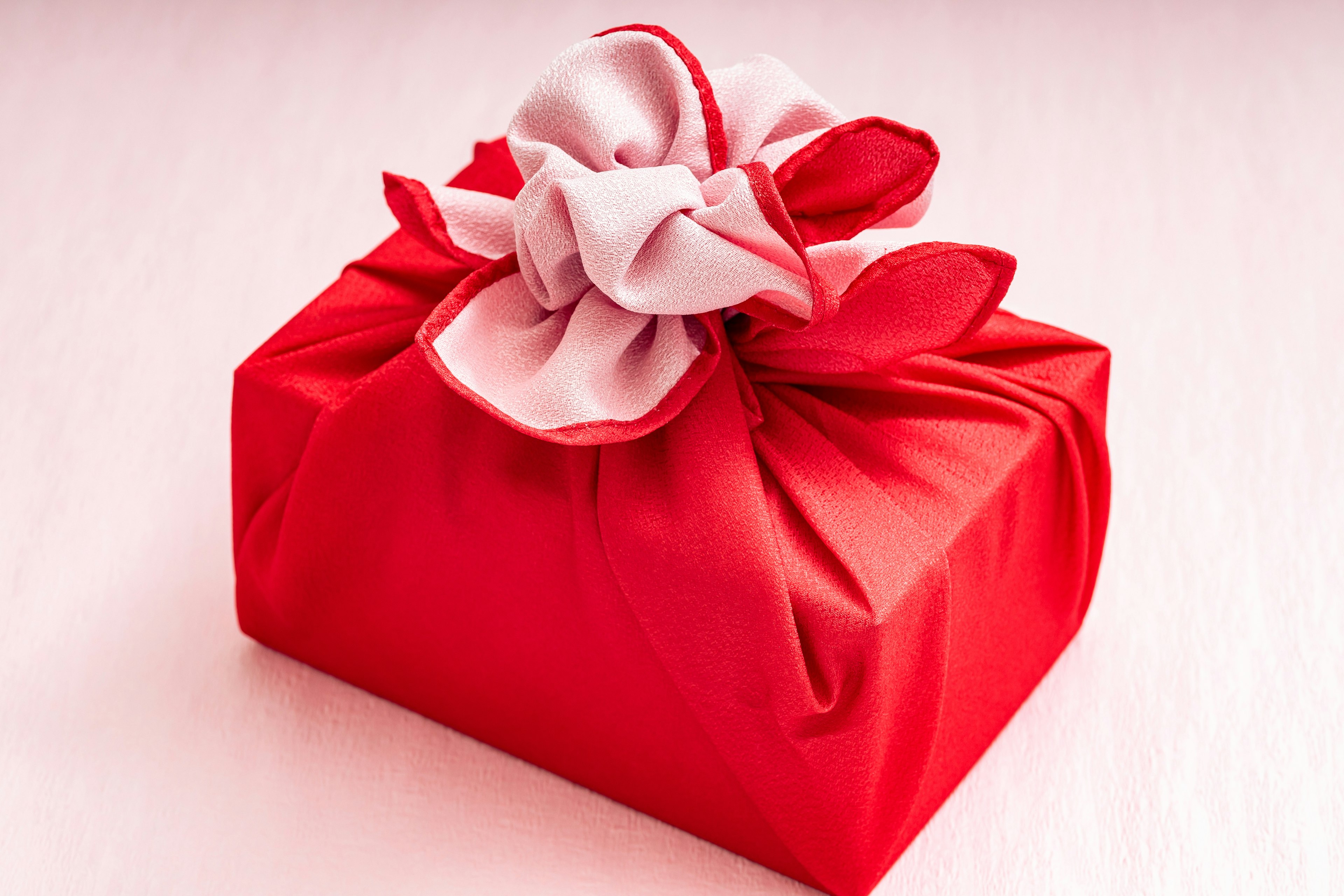 Red wrapped gift with a white fabric flower decoration