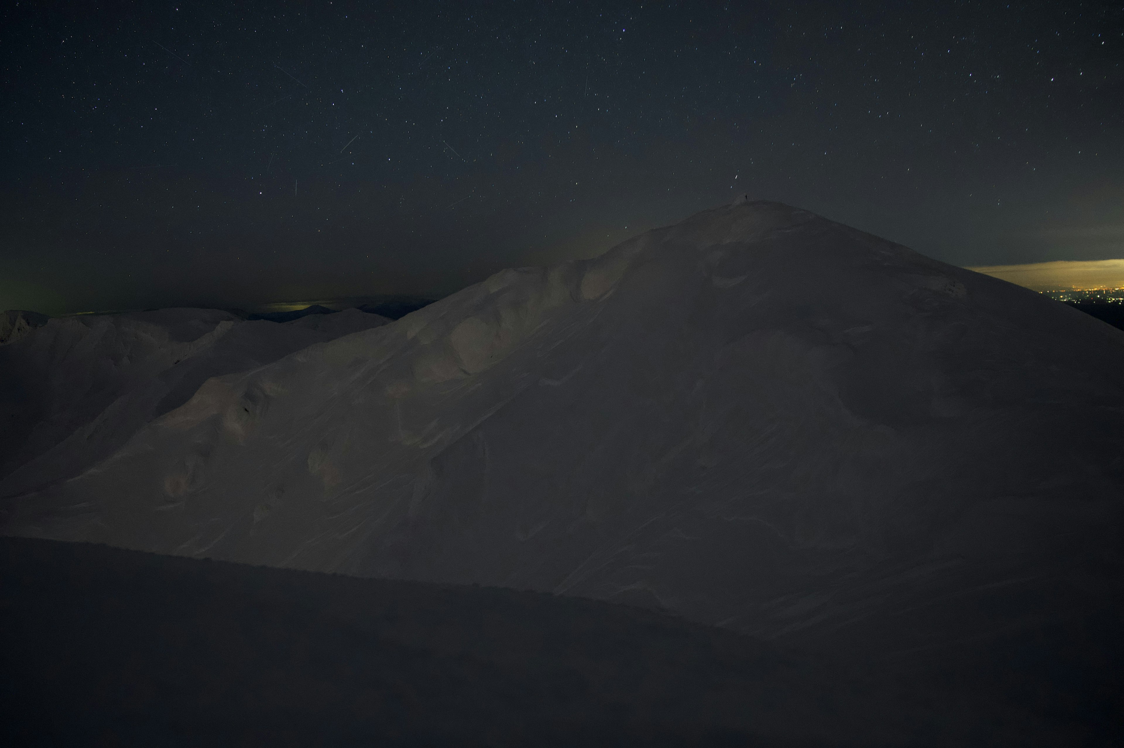 Paysage calme d'une montagne enneigée sous le ciel nocturne