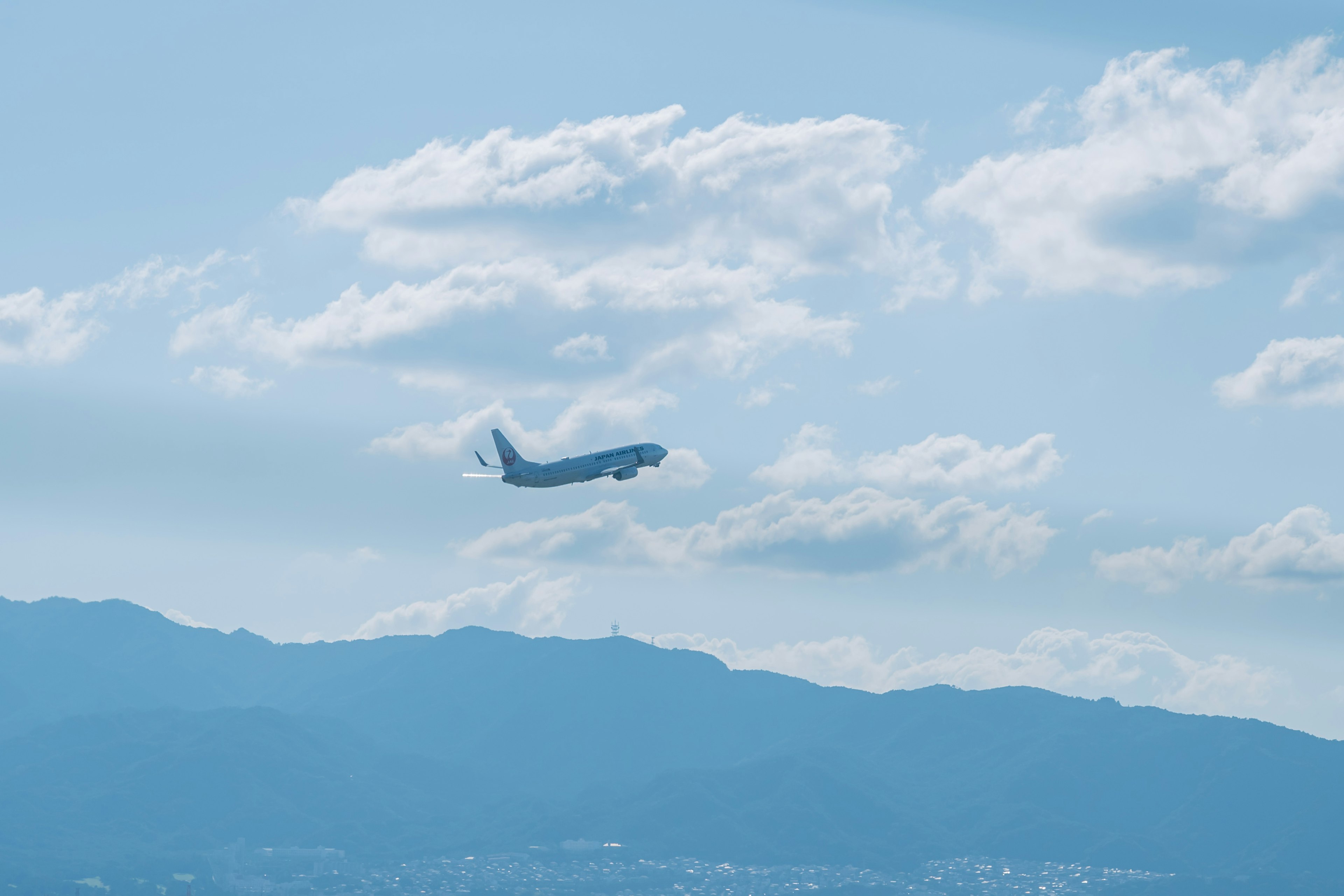 Aereo che vola in un cielo blu con nuvole