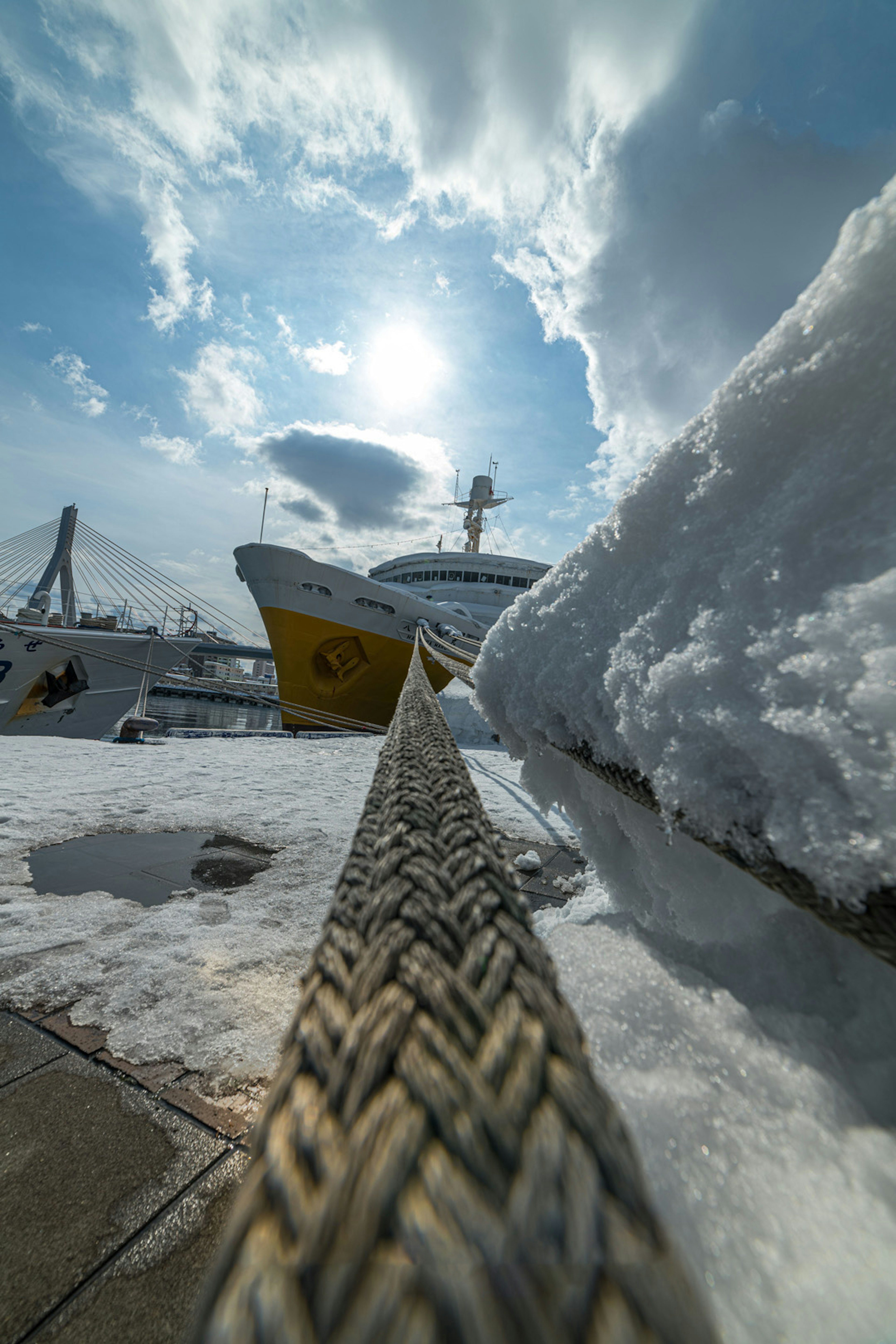 Cuerda cubierta de nieve con un barco y un cielo azul de fondo