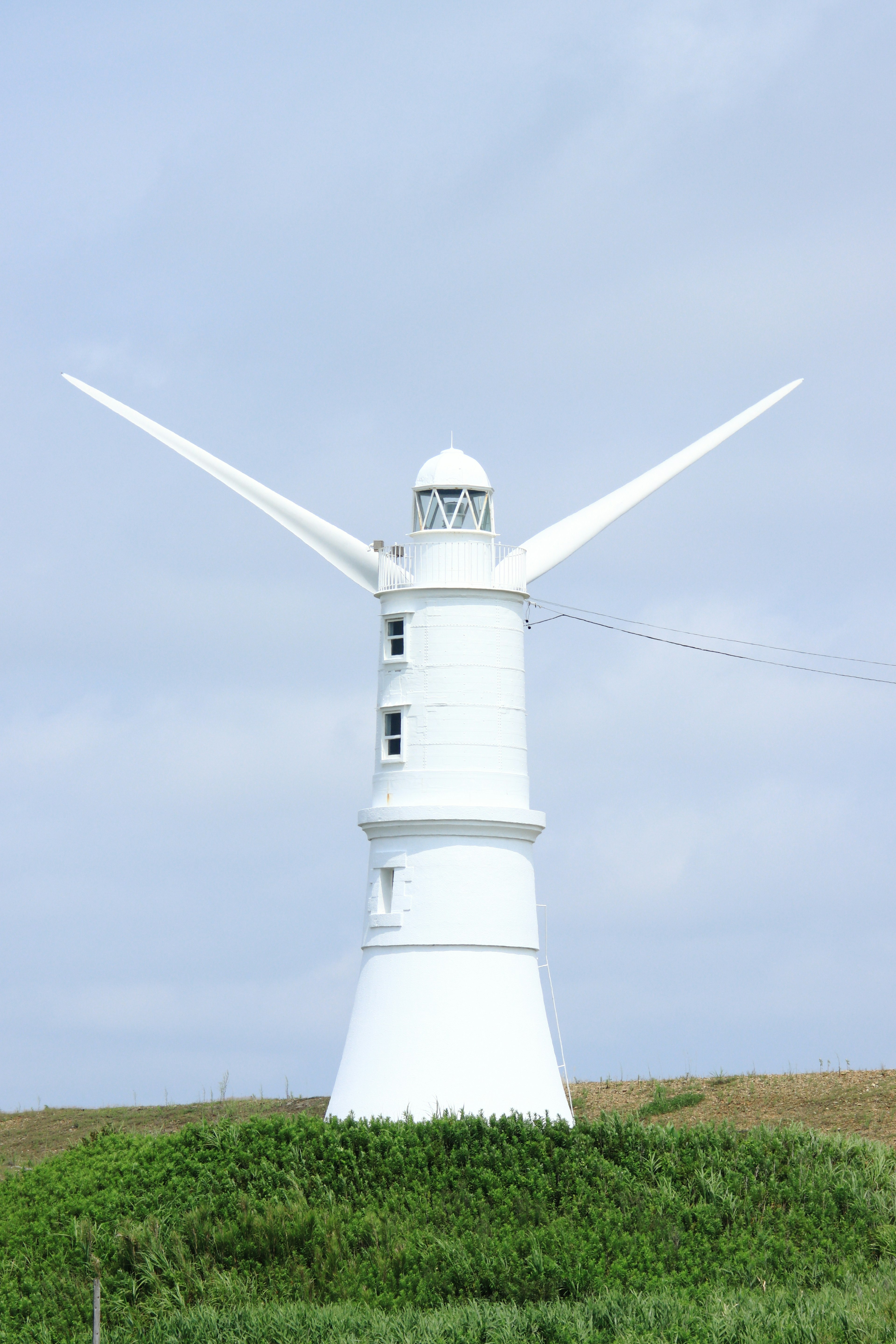 Moulin blanc se tenant sur une colline verte