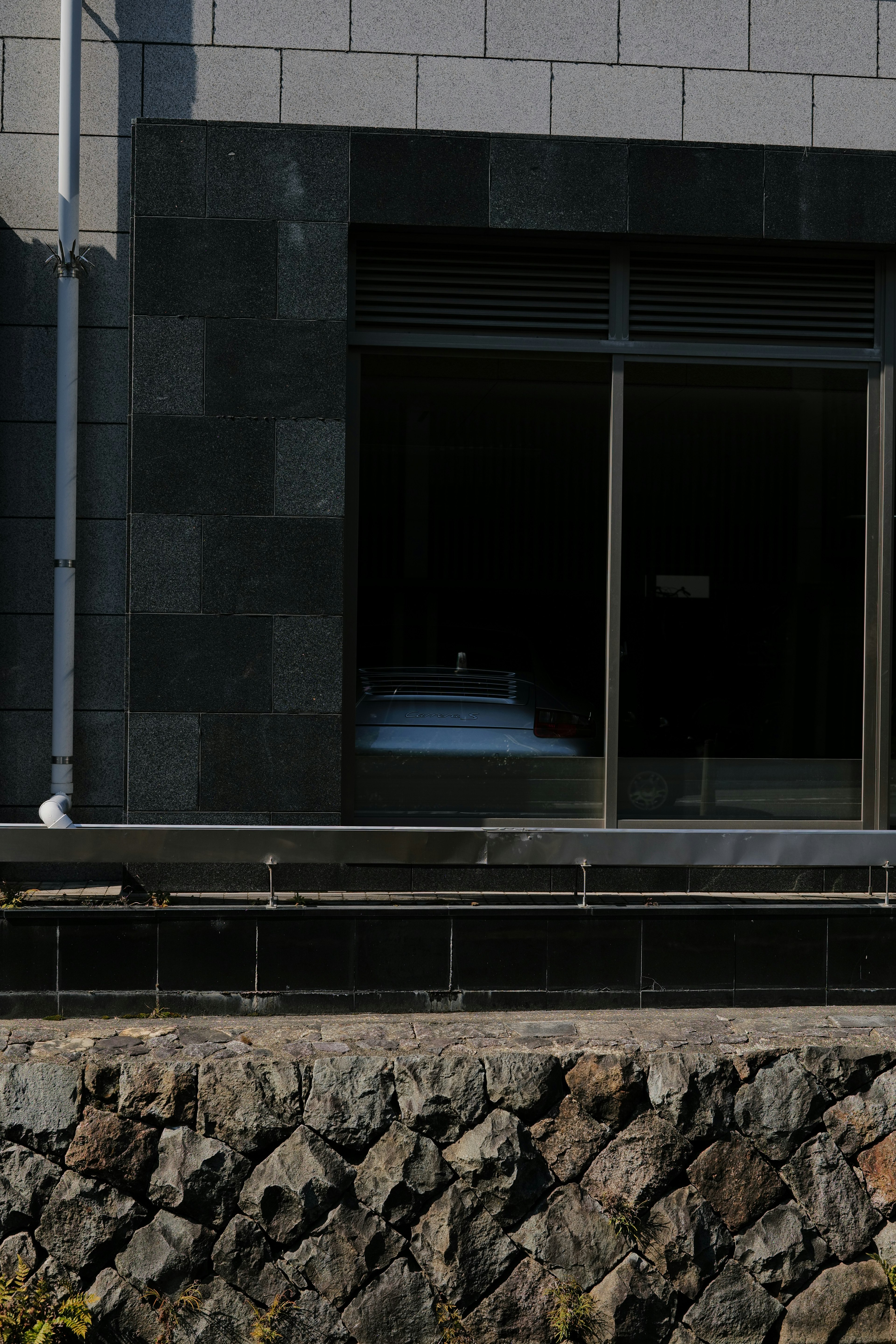 View of a black stone wall and a white object through a window