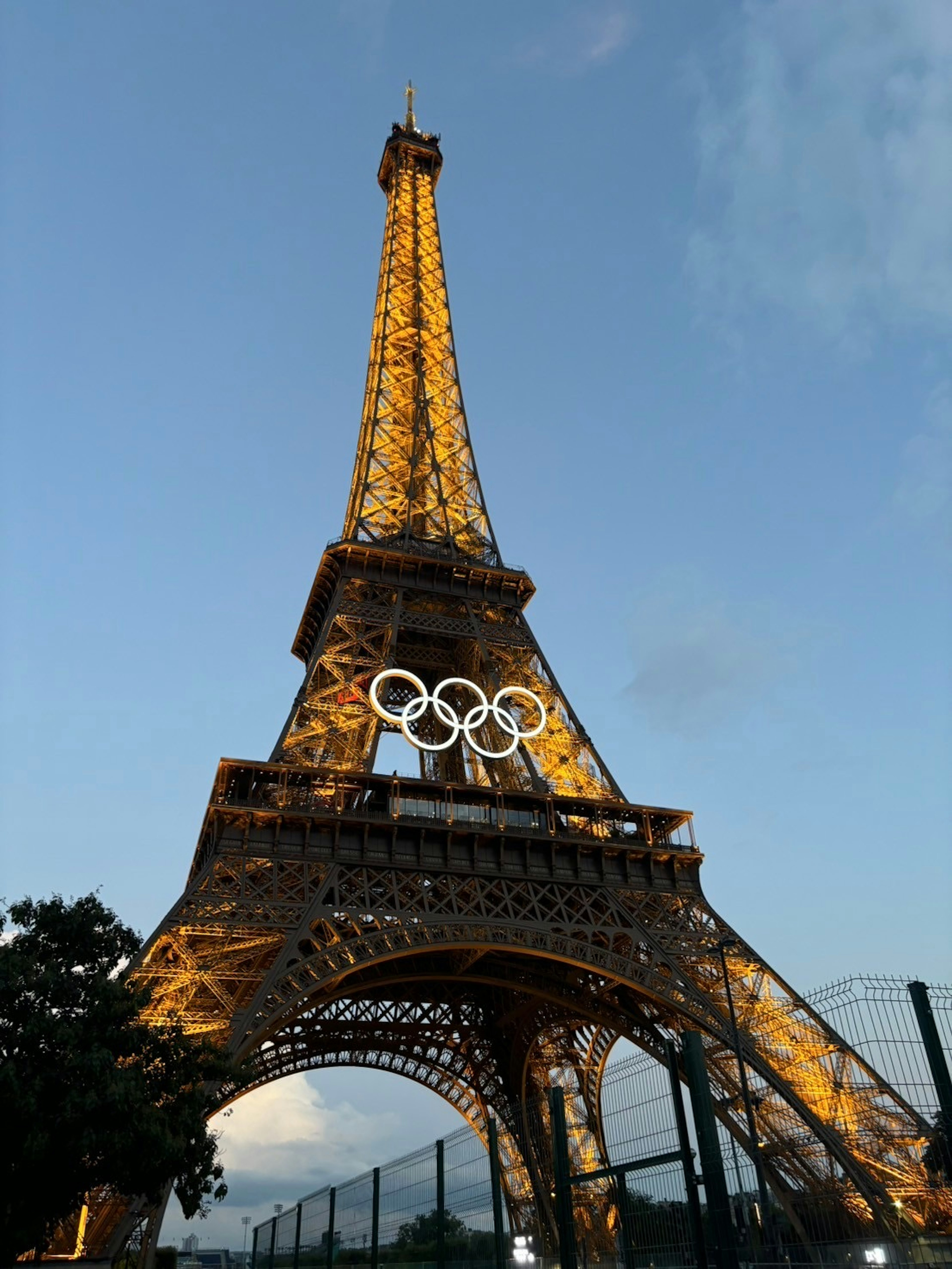 Eiffelturm geschmückt mit olympischen Ringen vor klarem Himmel