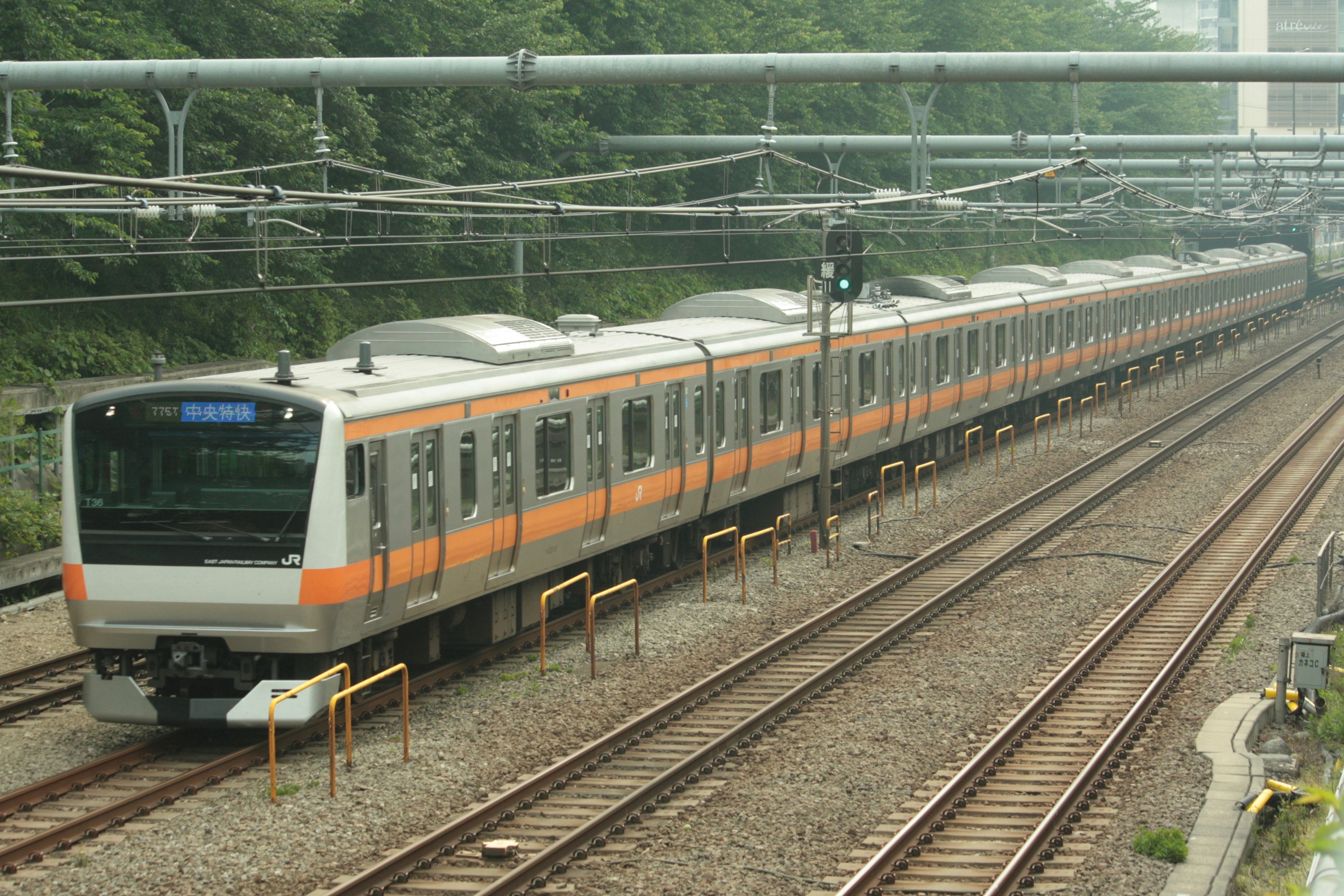 Un treno arancione e bianco che viaggia sui binari