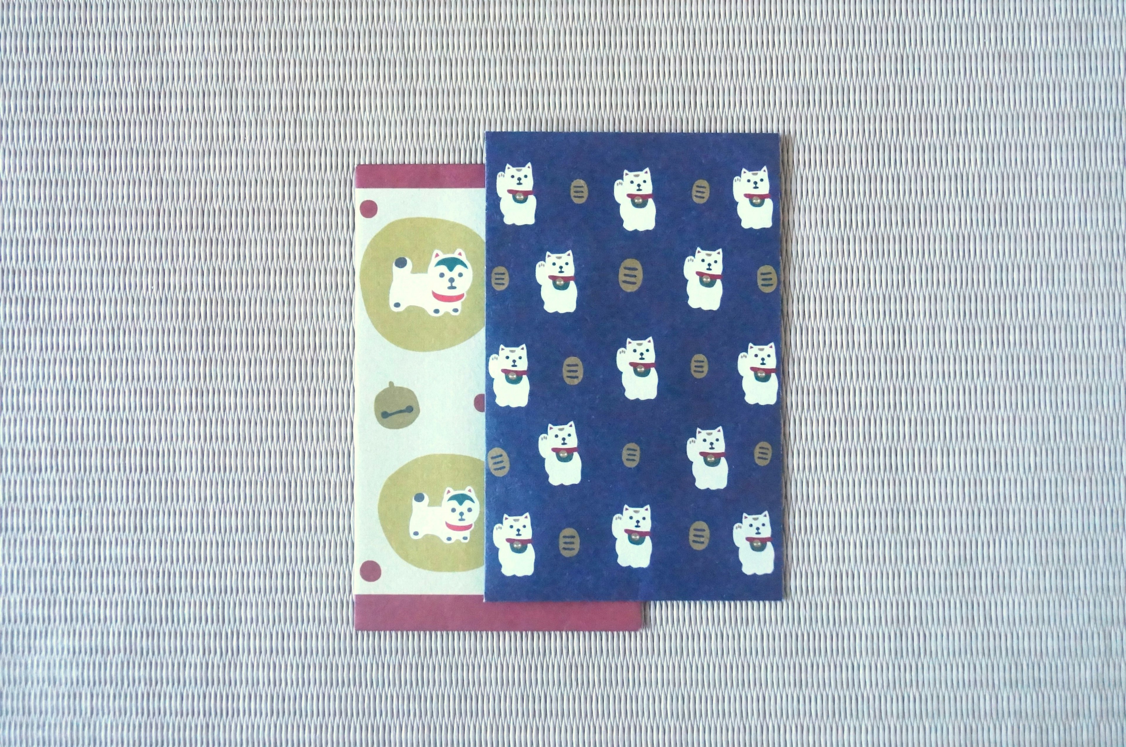 A blue card with white cat patterns and a green card featuring cat faces overlapping each other