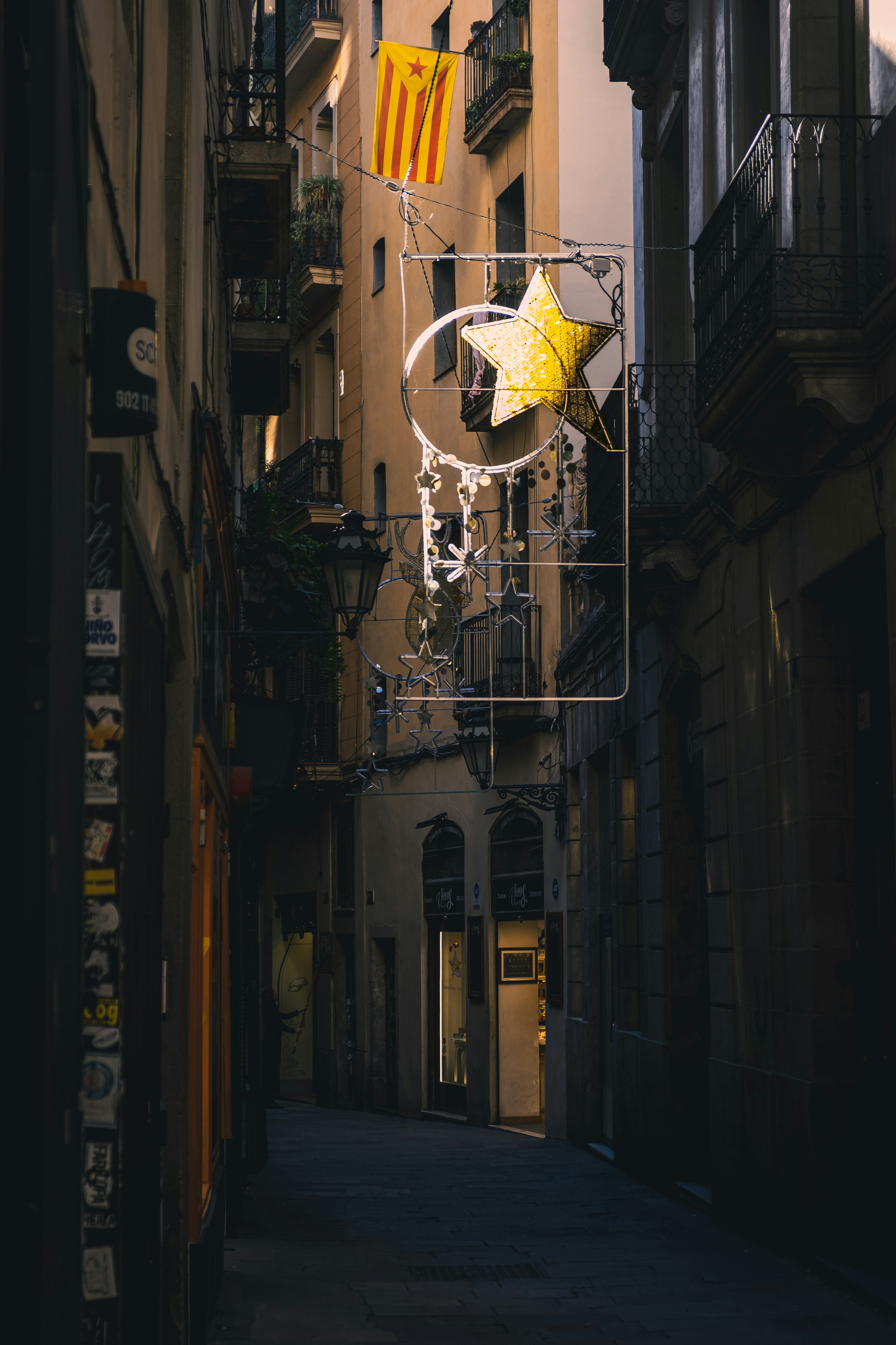 Rue étroite avec un panneau en forme d'étoile jaune et un drapeau catalan