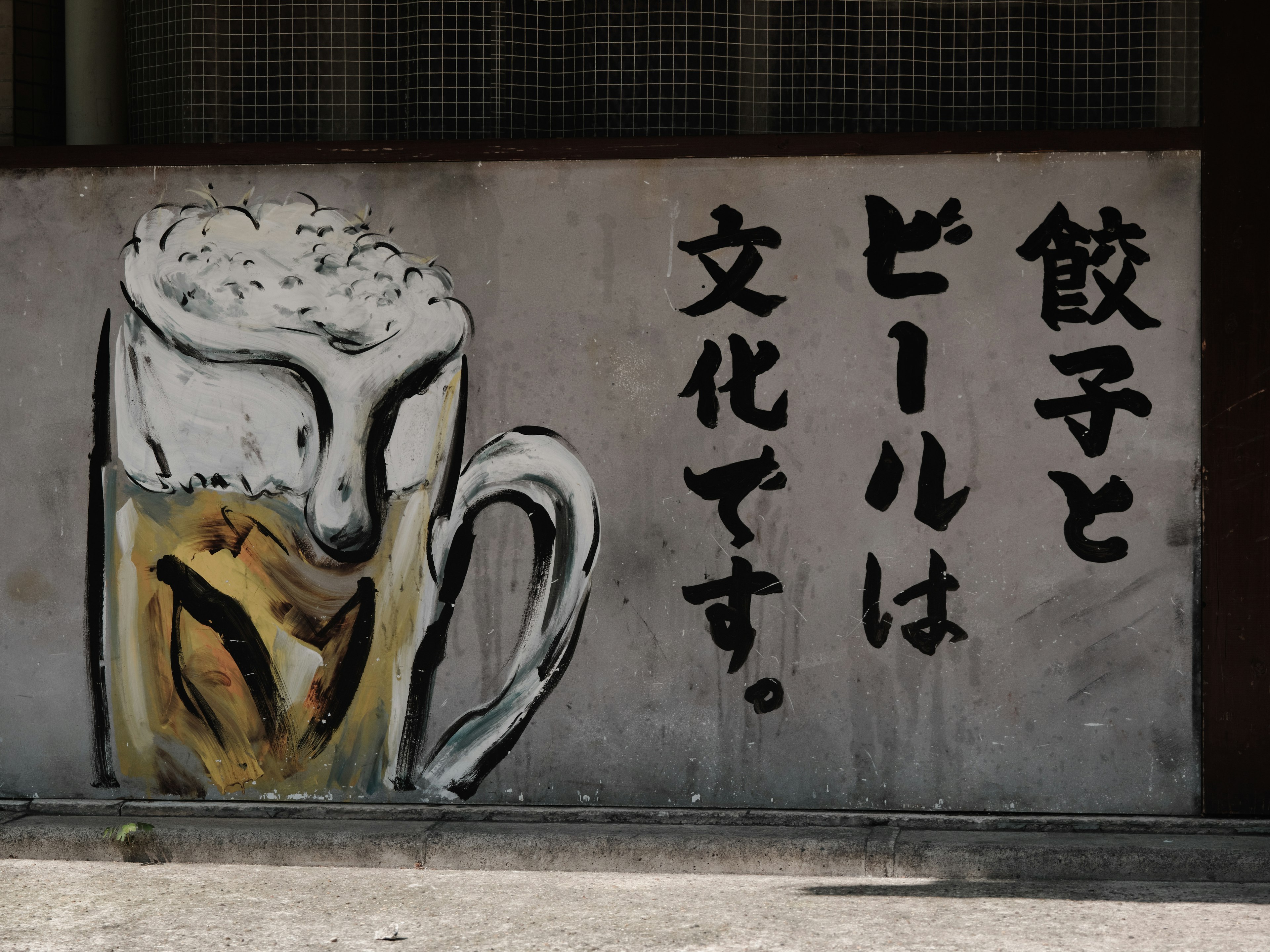 A mural depicting a beer mug with Japanese text about culture