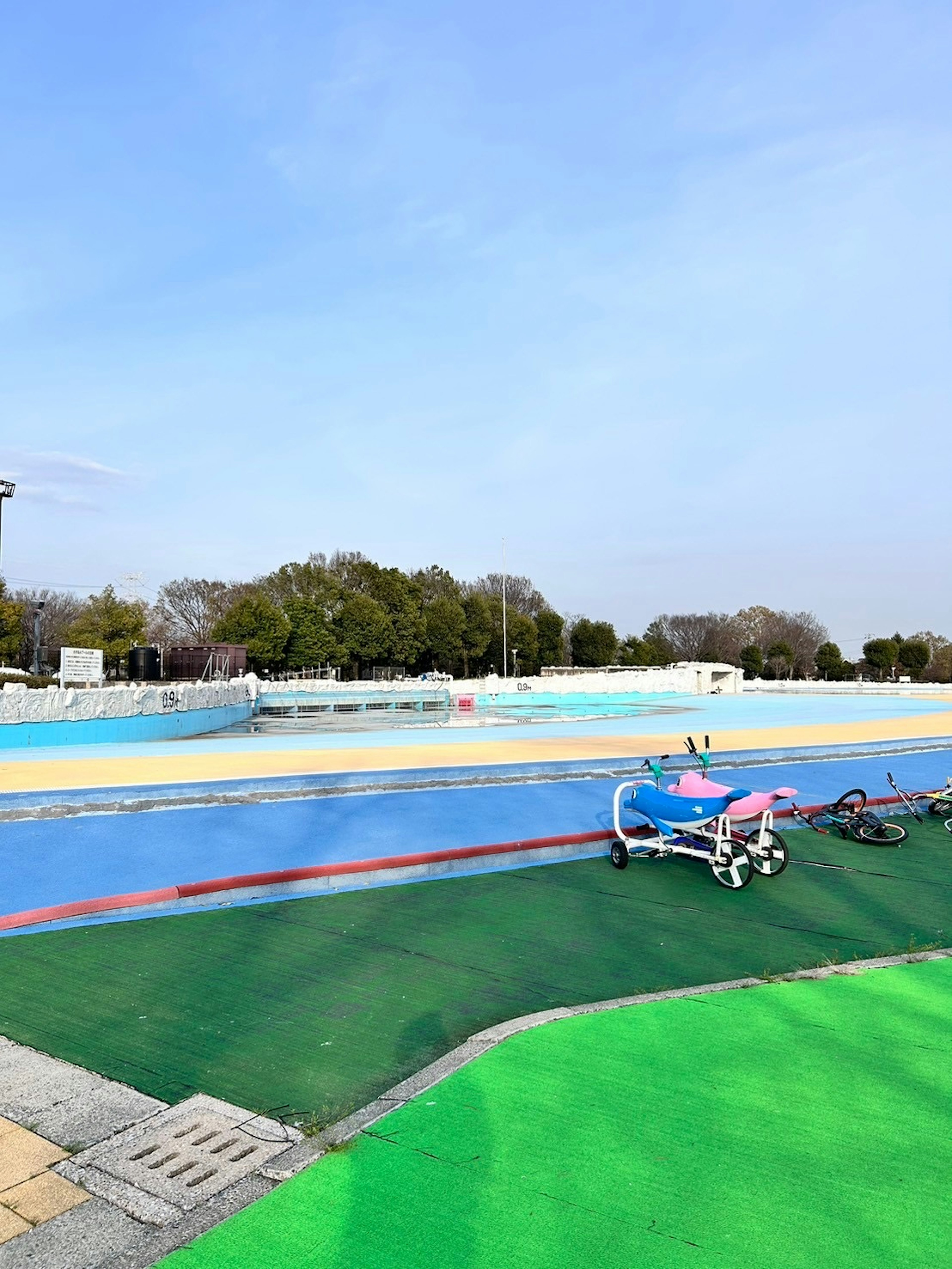 Lapangan olahraga berwarna-warni dan rumput hijau di bawah langit biru