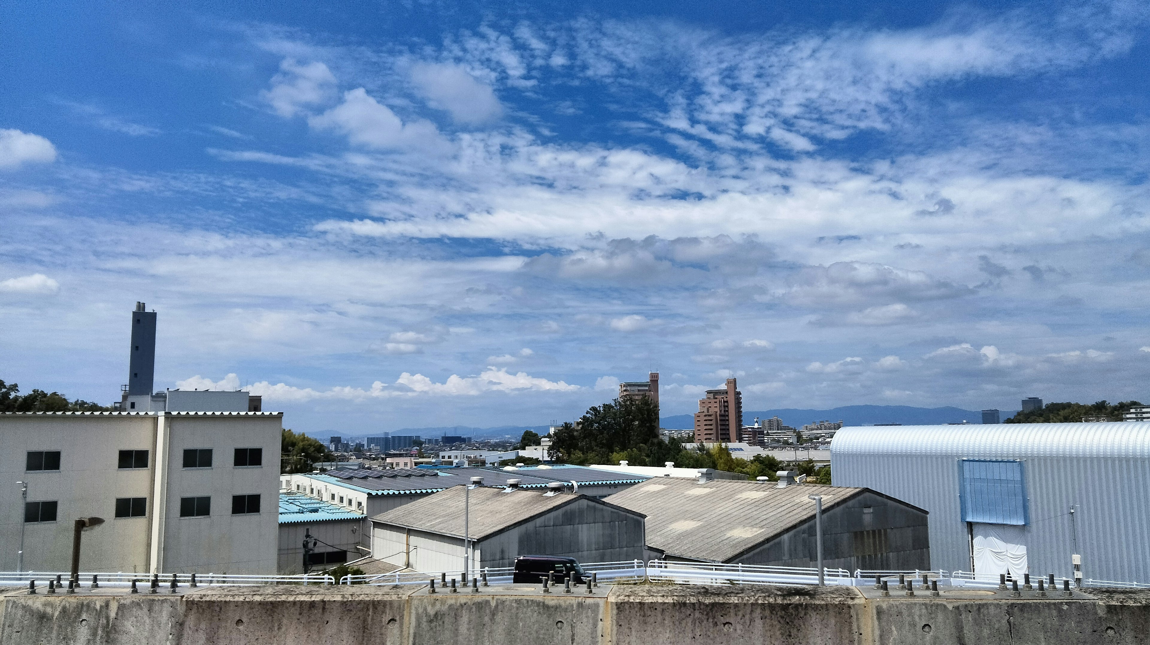 Industrial landscape featuring blue sky and scattered clouds