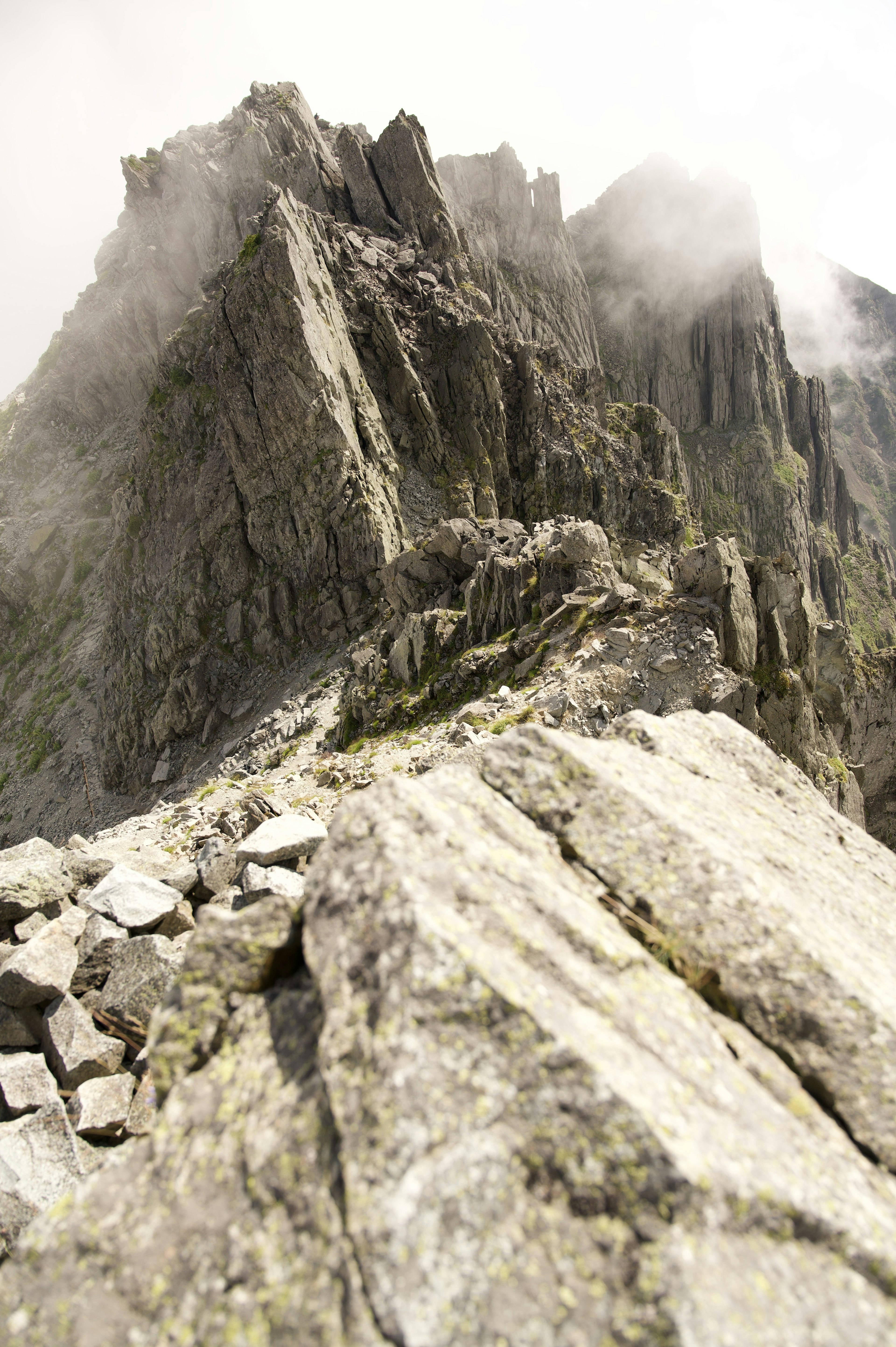 Cara de roca de montaña empinada con atmósfera brumosa