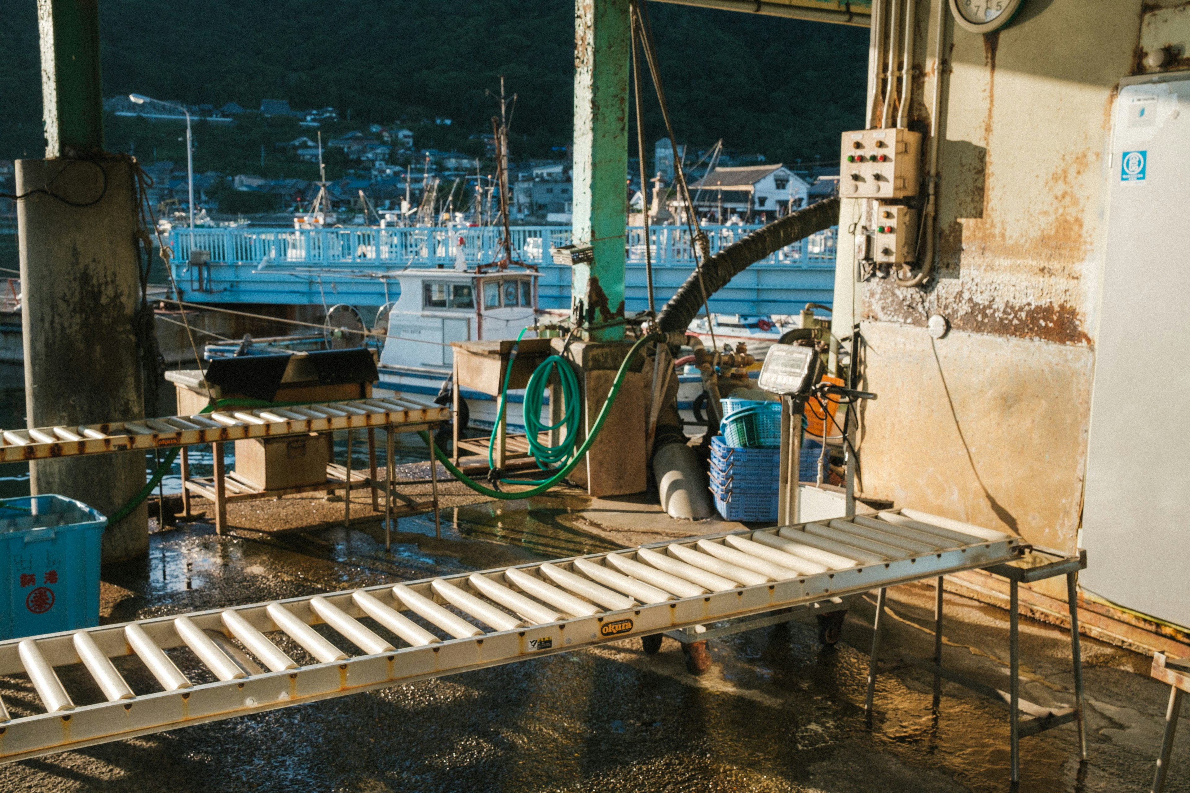 Interno di un molo di pesca con barche da pesca sullo sfondo attrezzature su pavimento bagnato