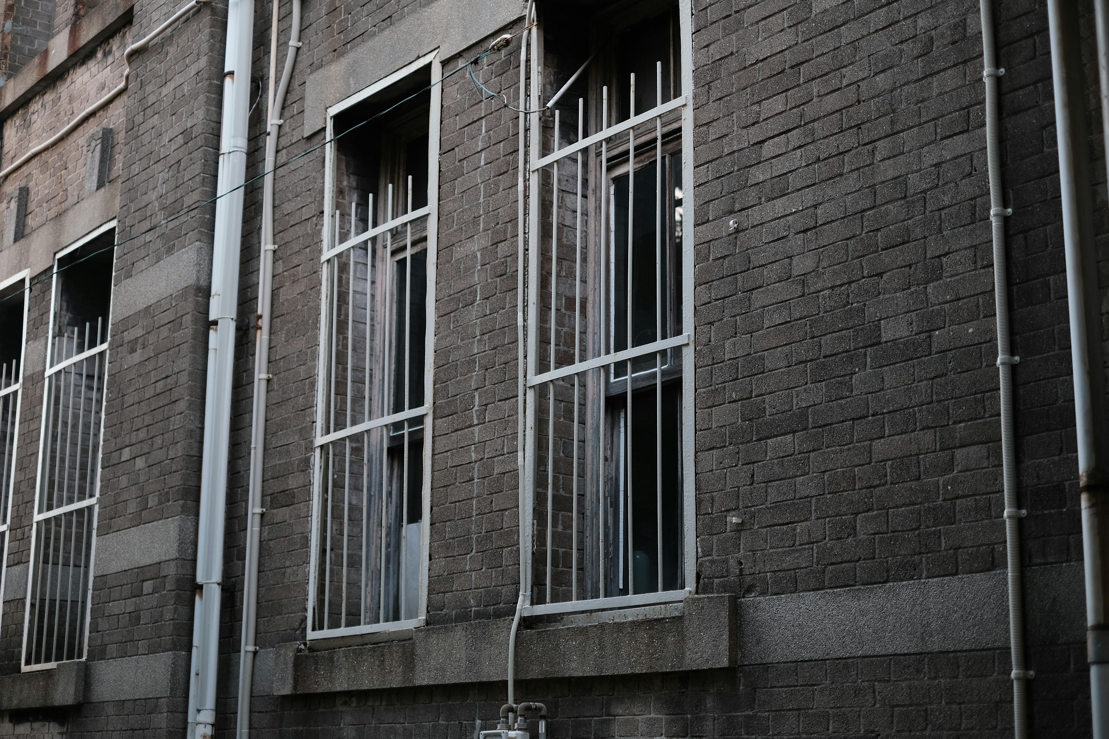 Ventanas con rejas de hierro en la pared de un edificio antiguo