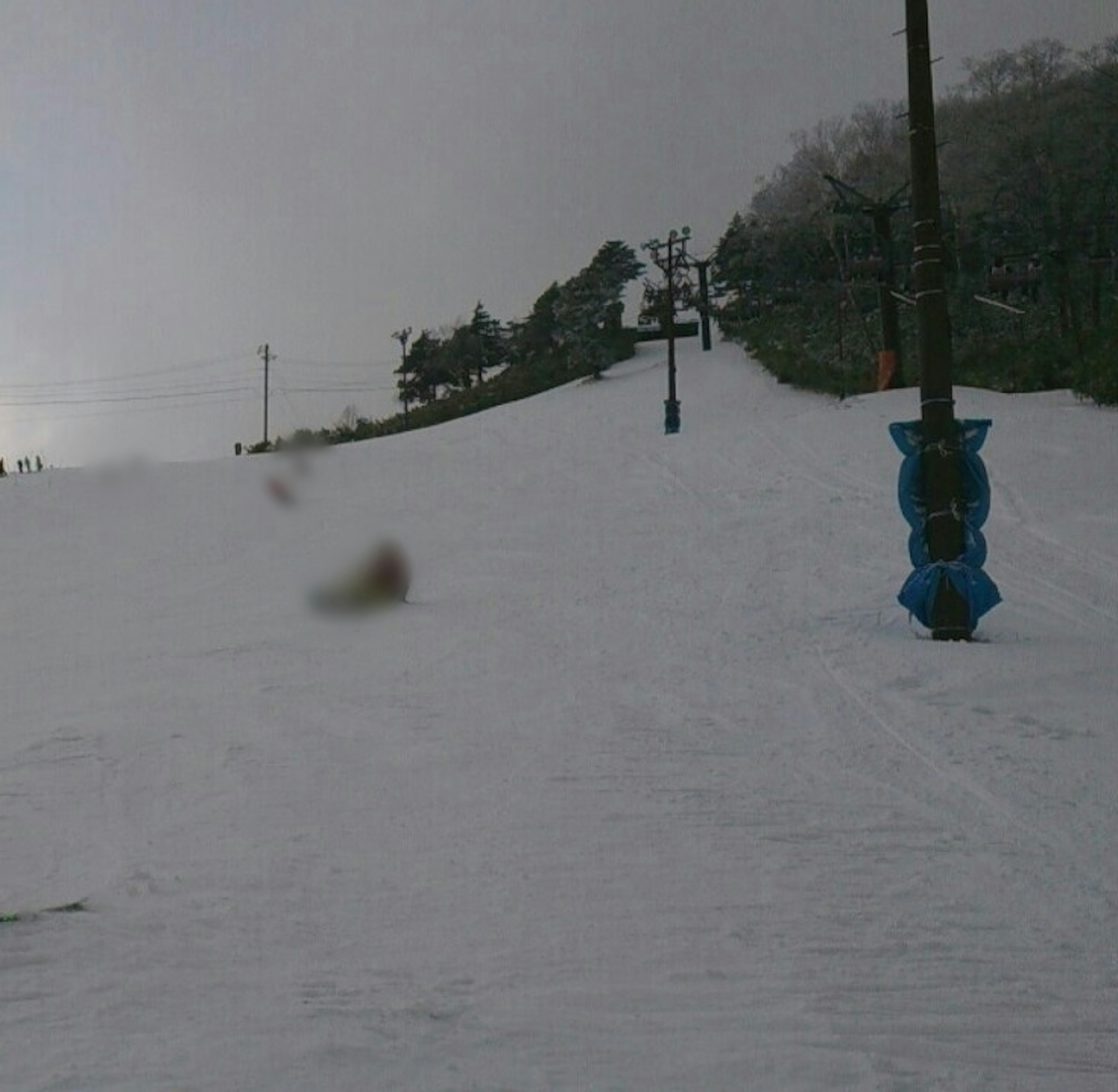 Snow-covered ski slope with a ski lift and snowy terrain