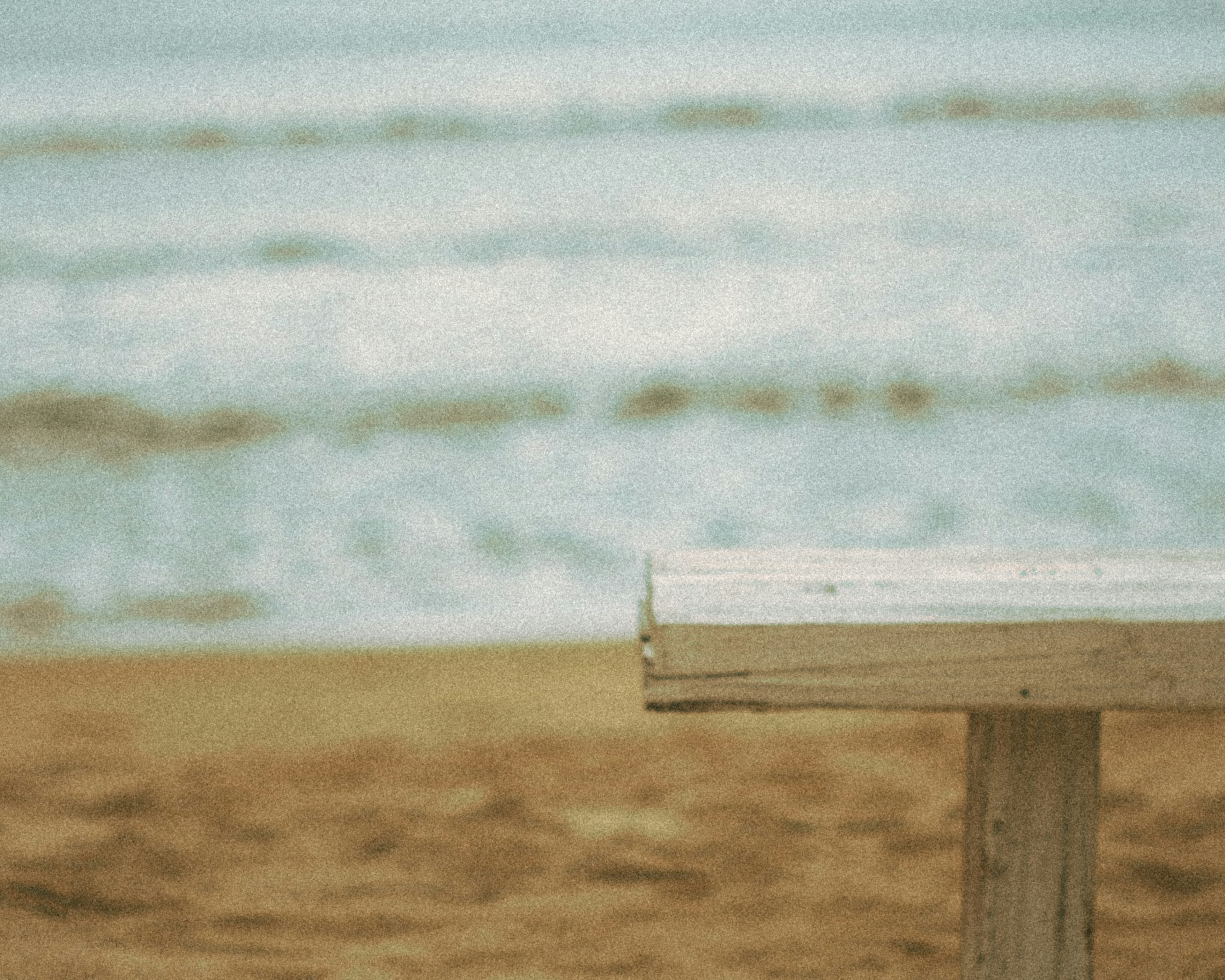 Wooden bench near the beach with a calm ocean view