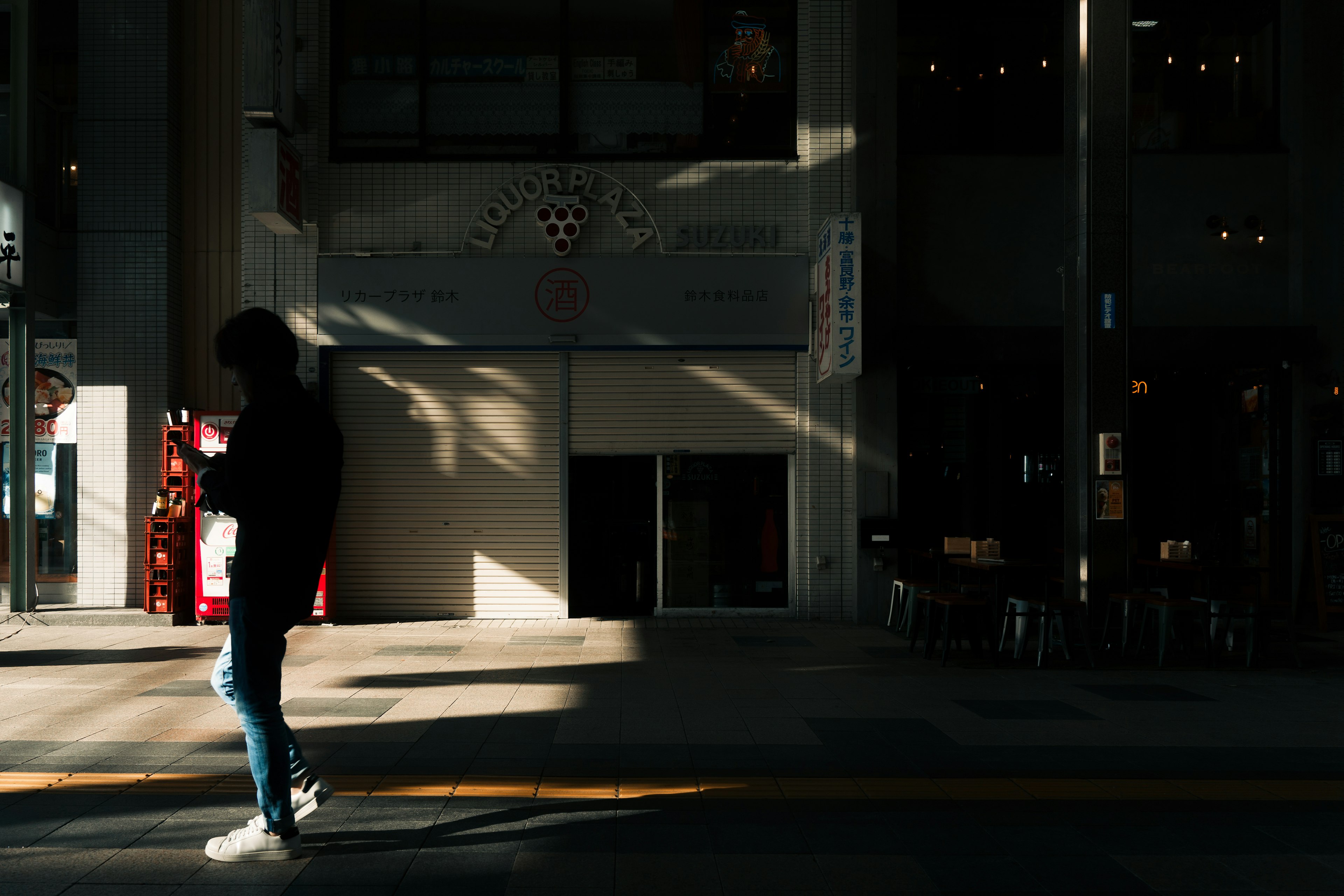 Silhouette of a person walking in shadow with contrasting bright light