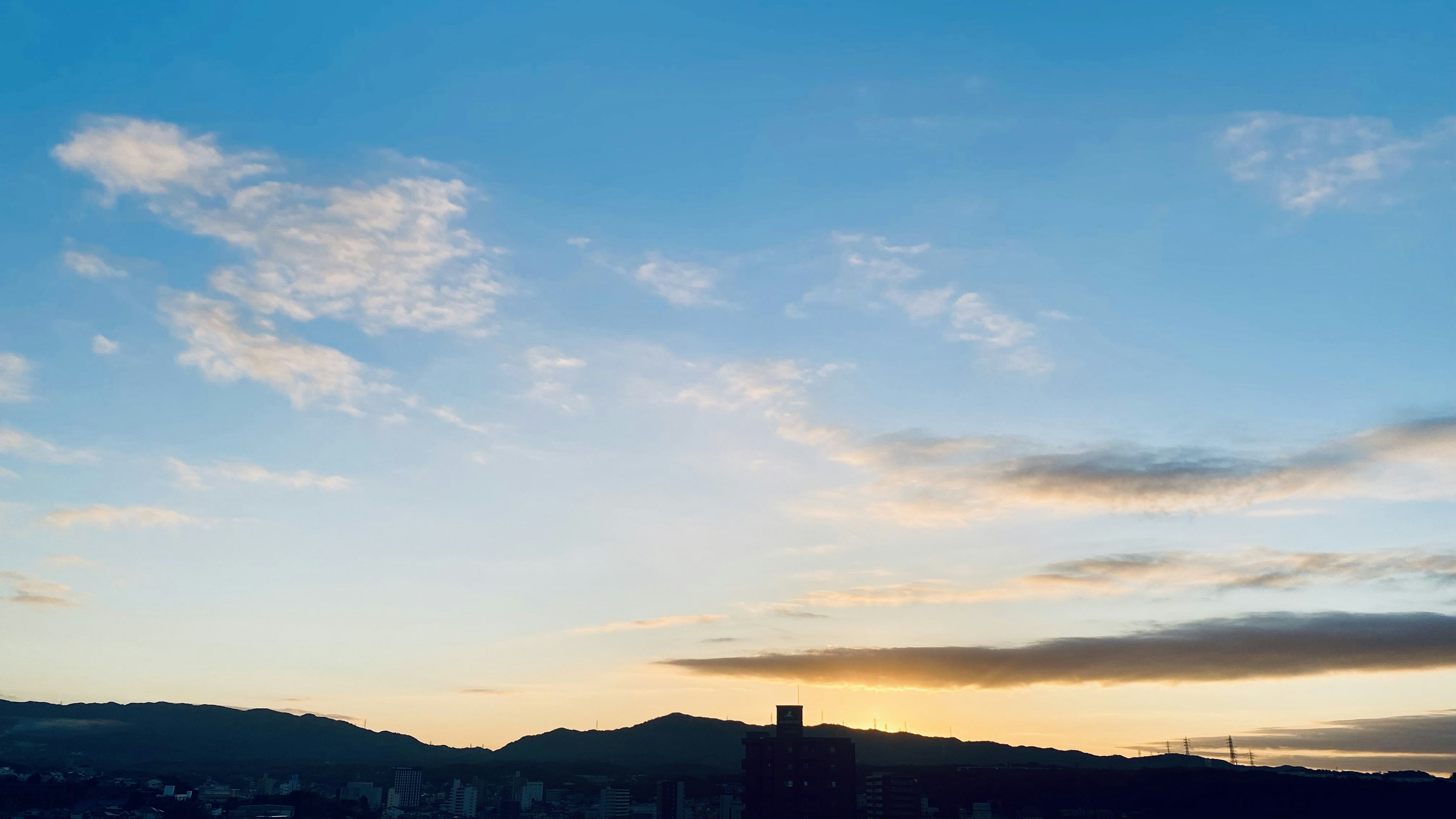 Vista panoramica del cielo blu con nuvole e silhouette delle montagne