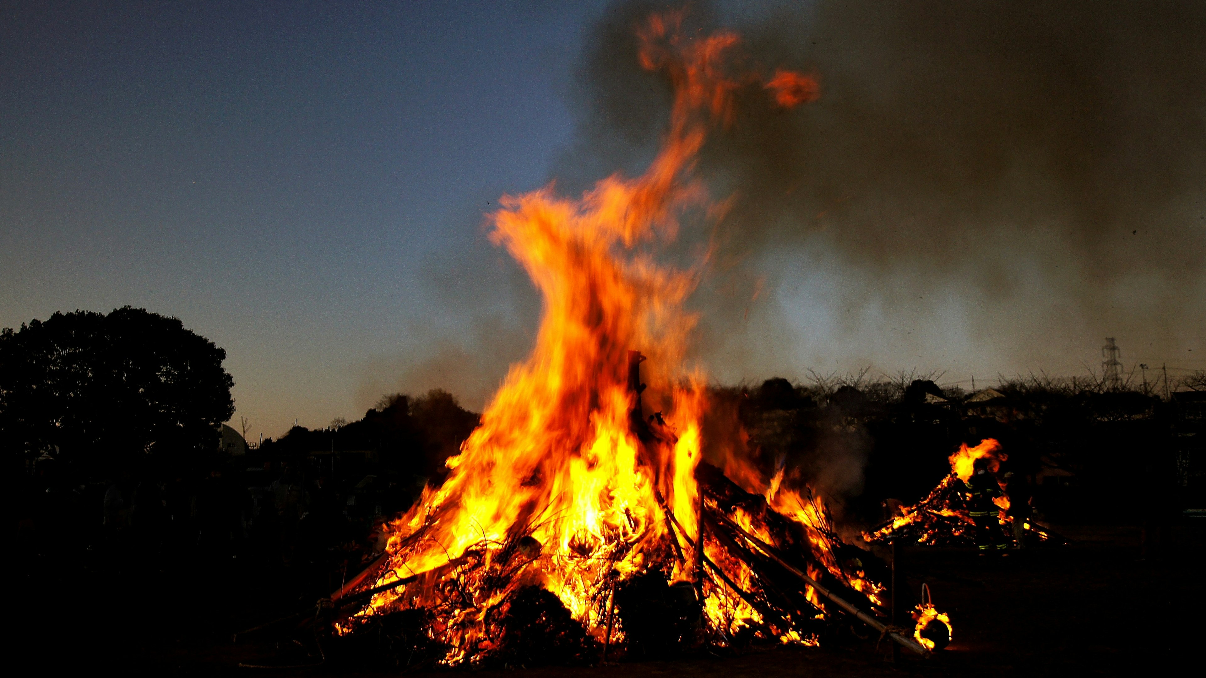 Large bonfire flames under a night sky