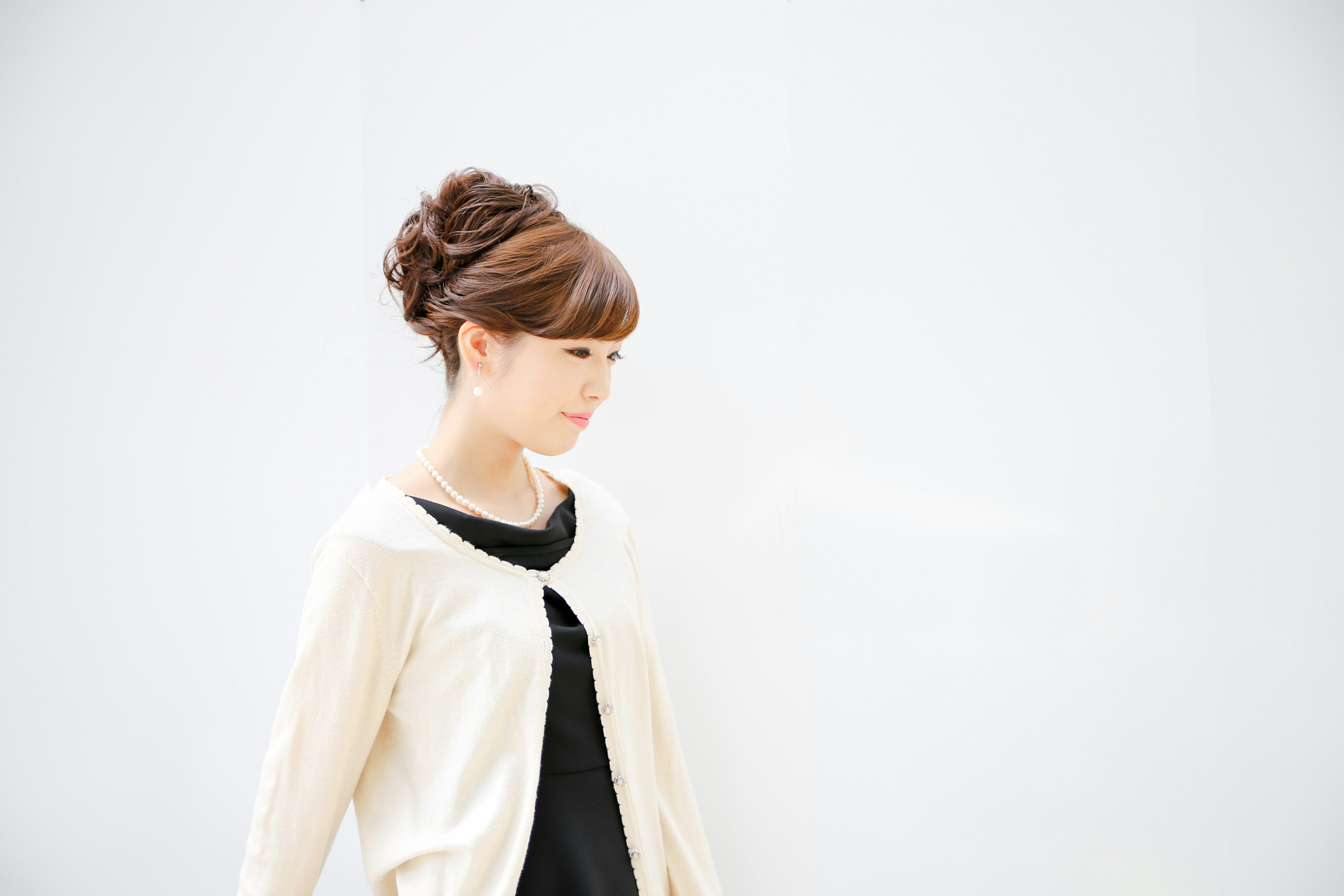 Side profile of a woman standing in front of a white background Casual outfit and styled hair