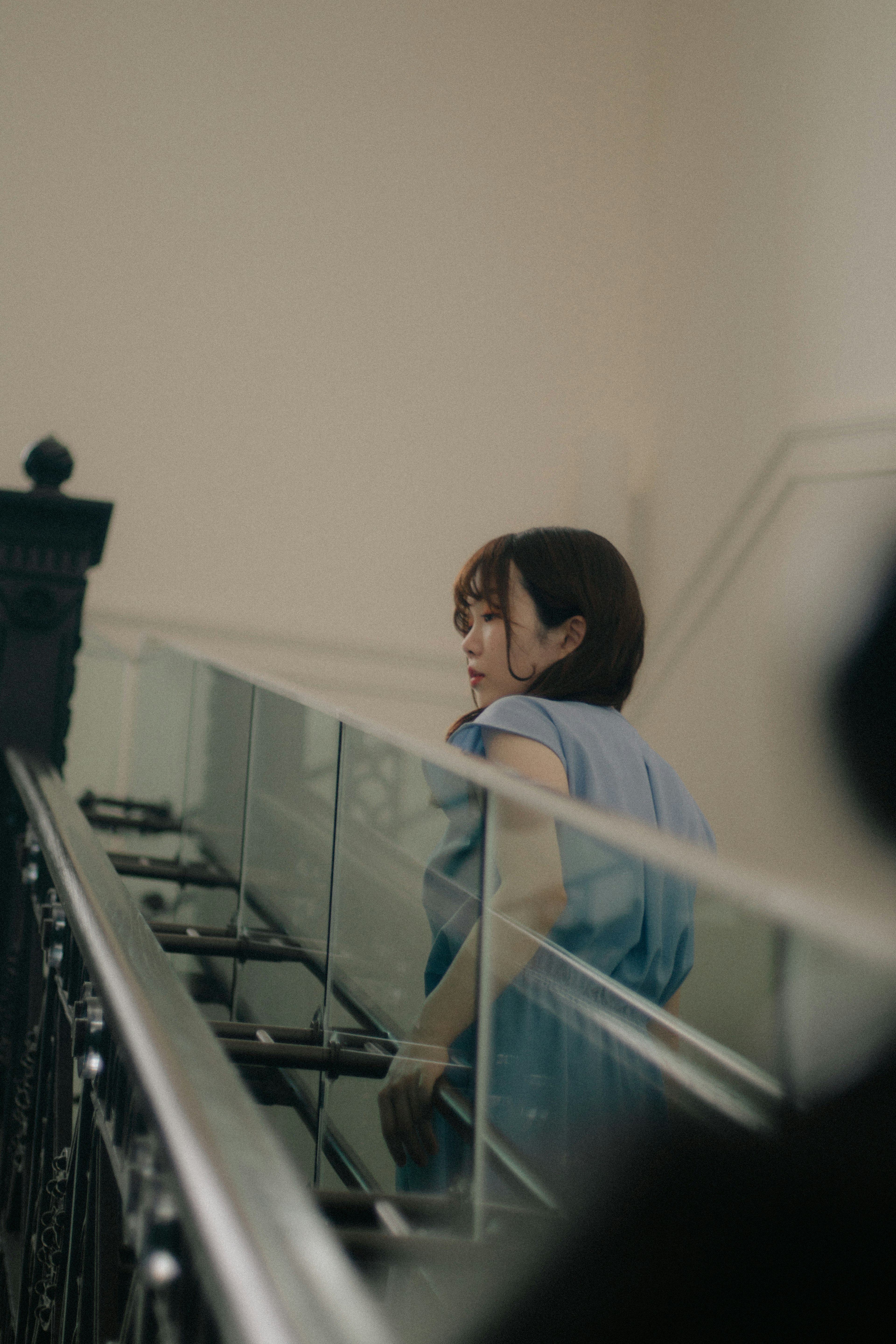 Una mujer con un atuendo azul claro subiendo las escaleras