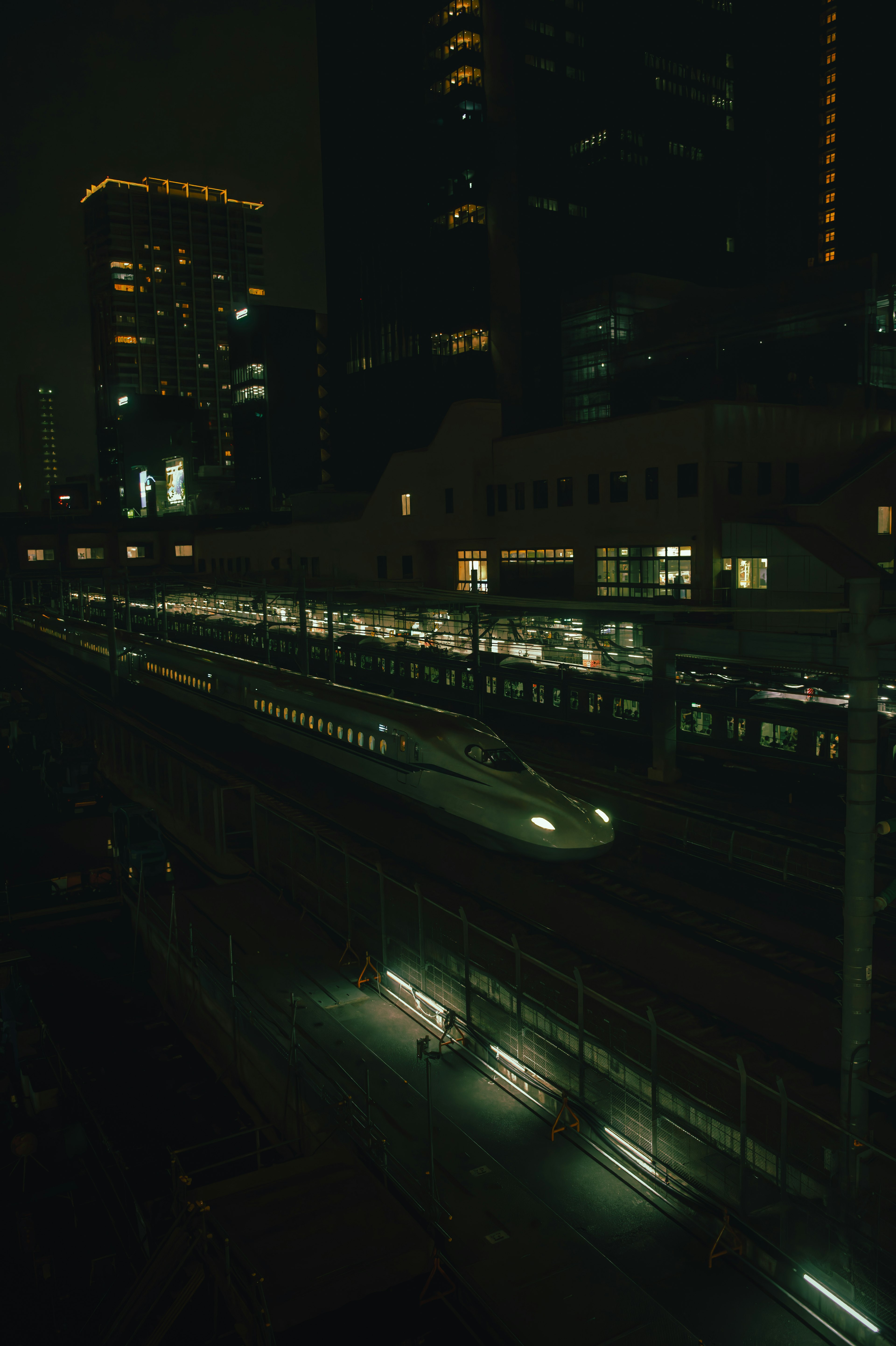 Shinkansen train illuminated at night in a city