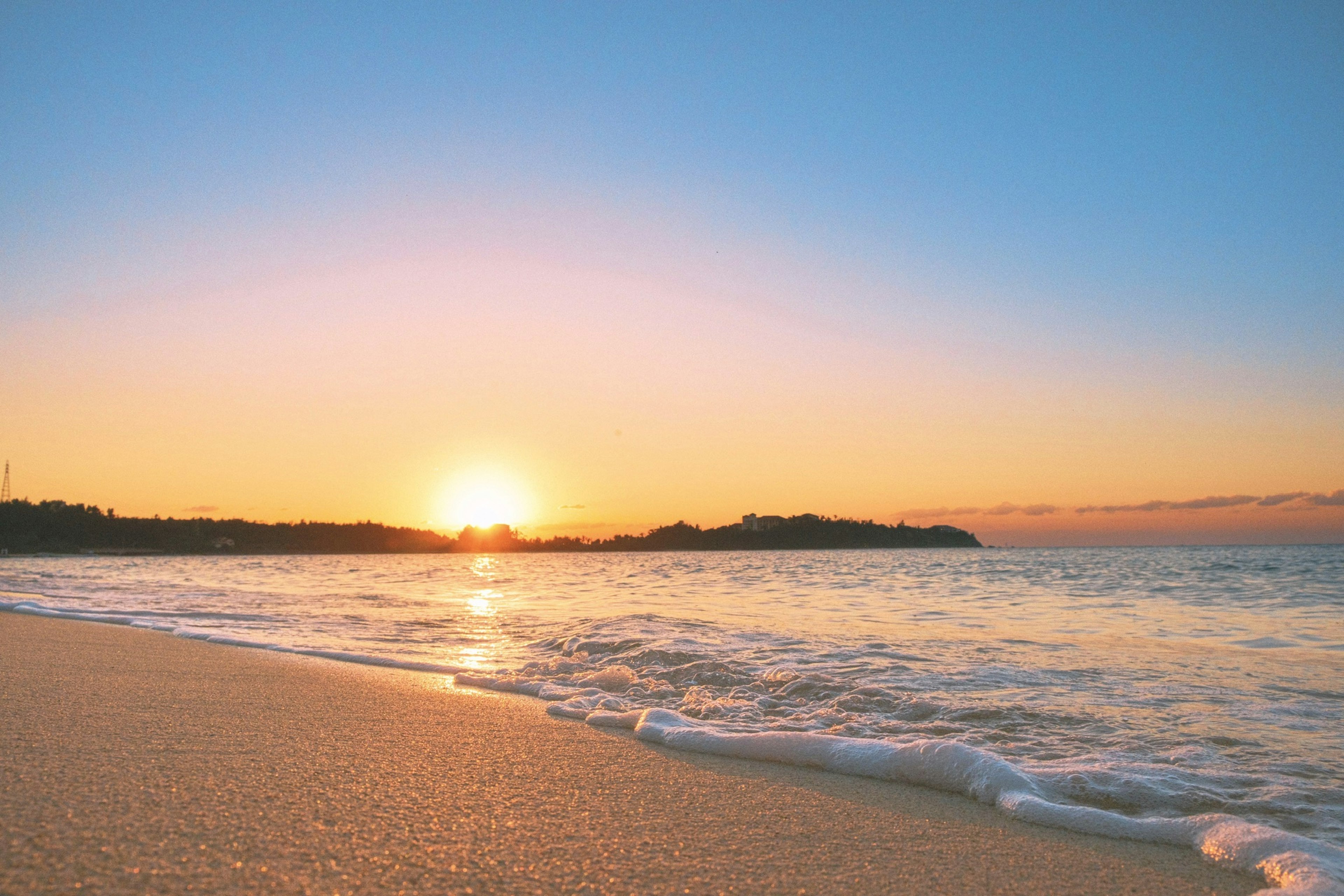 ทิวทัศน์ชายหาดที่สวยงามพร้อมพระอาทิตย์ตกดินเหนือมหาสมุทร