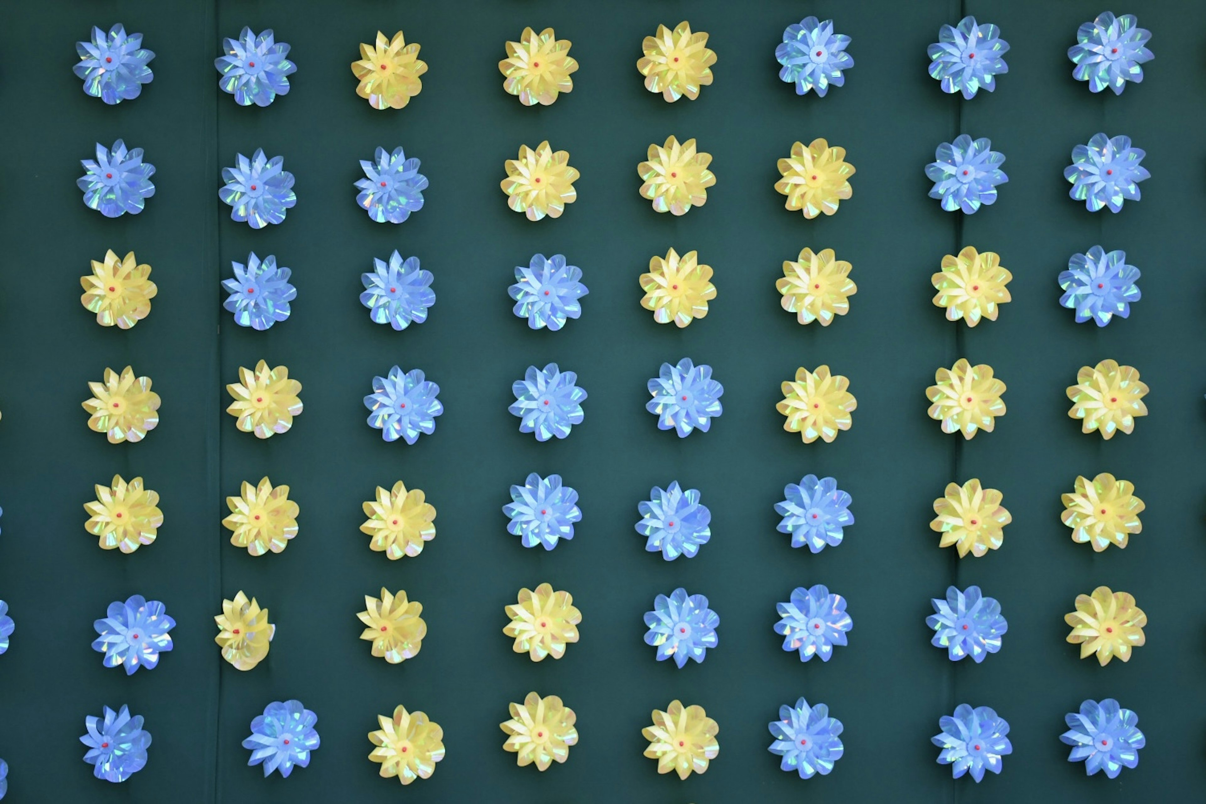 Un mur décoré de formes de fleurs bleues et jaunes disposées en grille