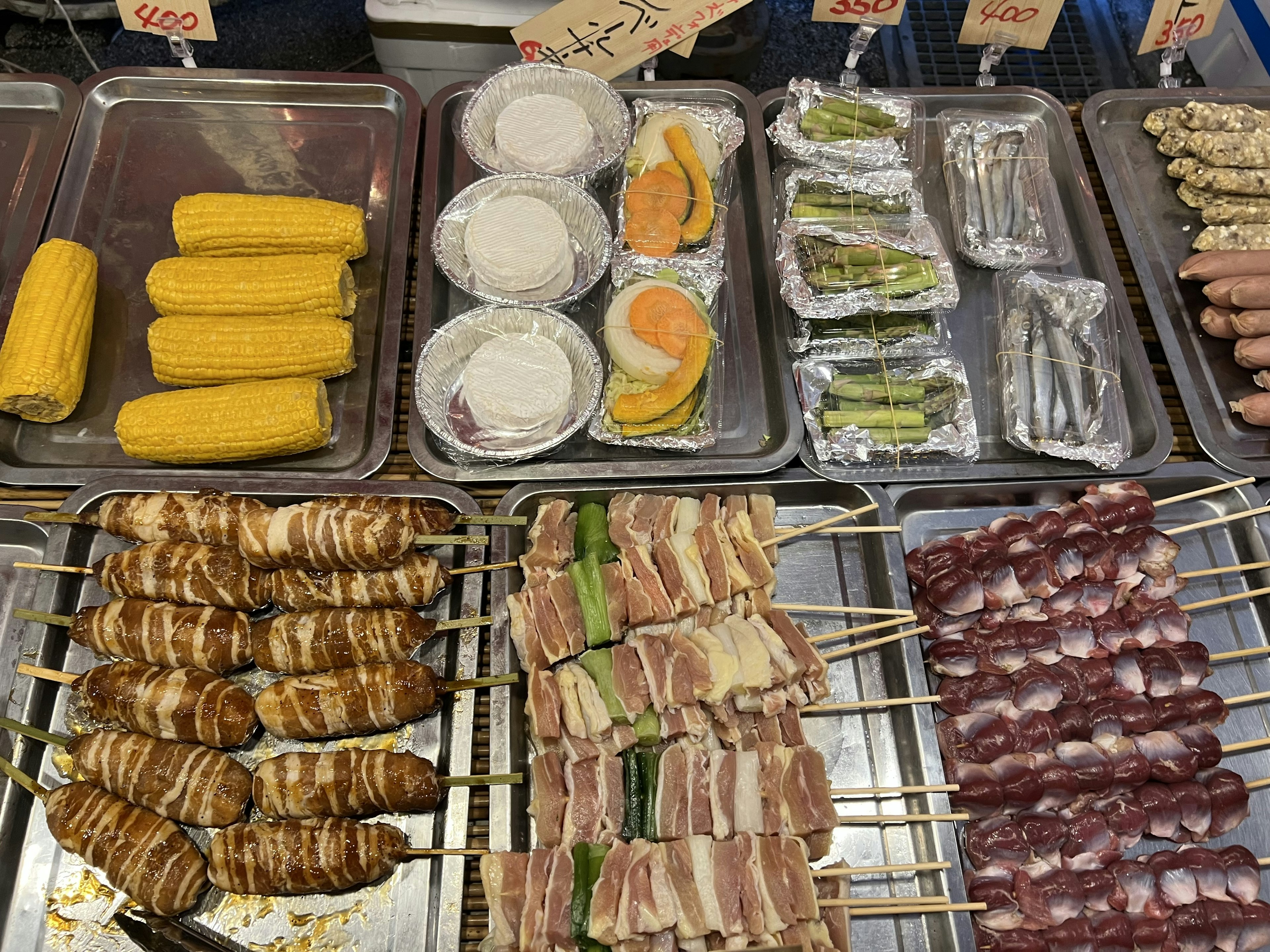 Street food stall featuring skewered meats and vegetables