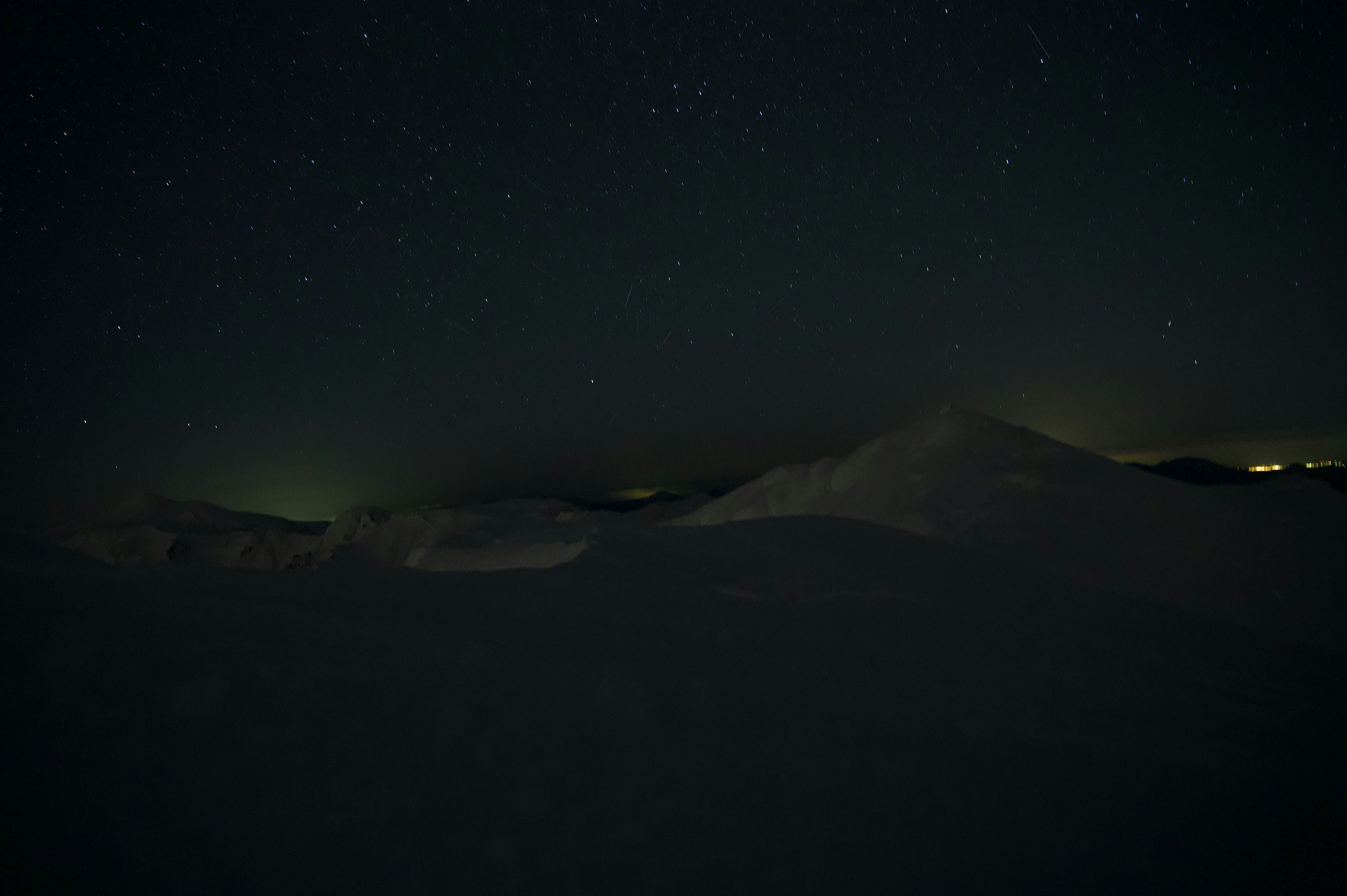 Cielo estrellado sobre montañas nevadas