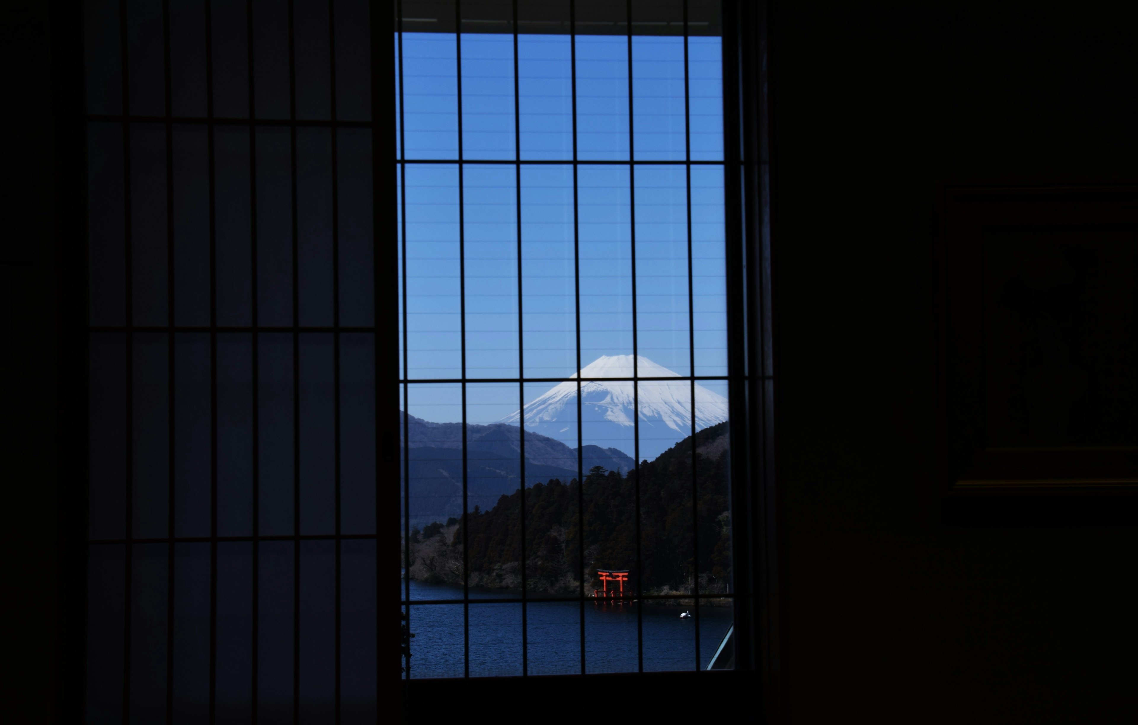 Scenic view of a mountain through a window with a blue sky