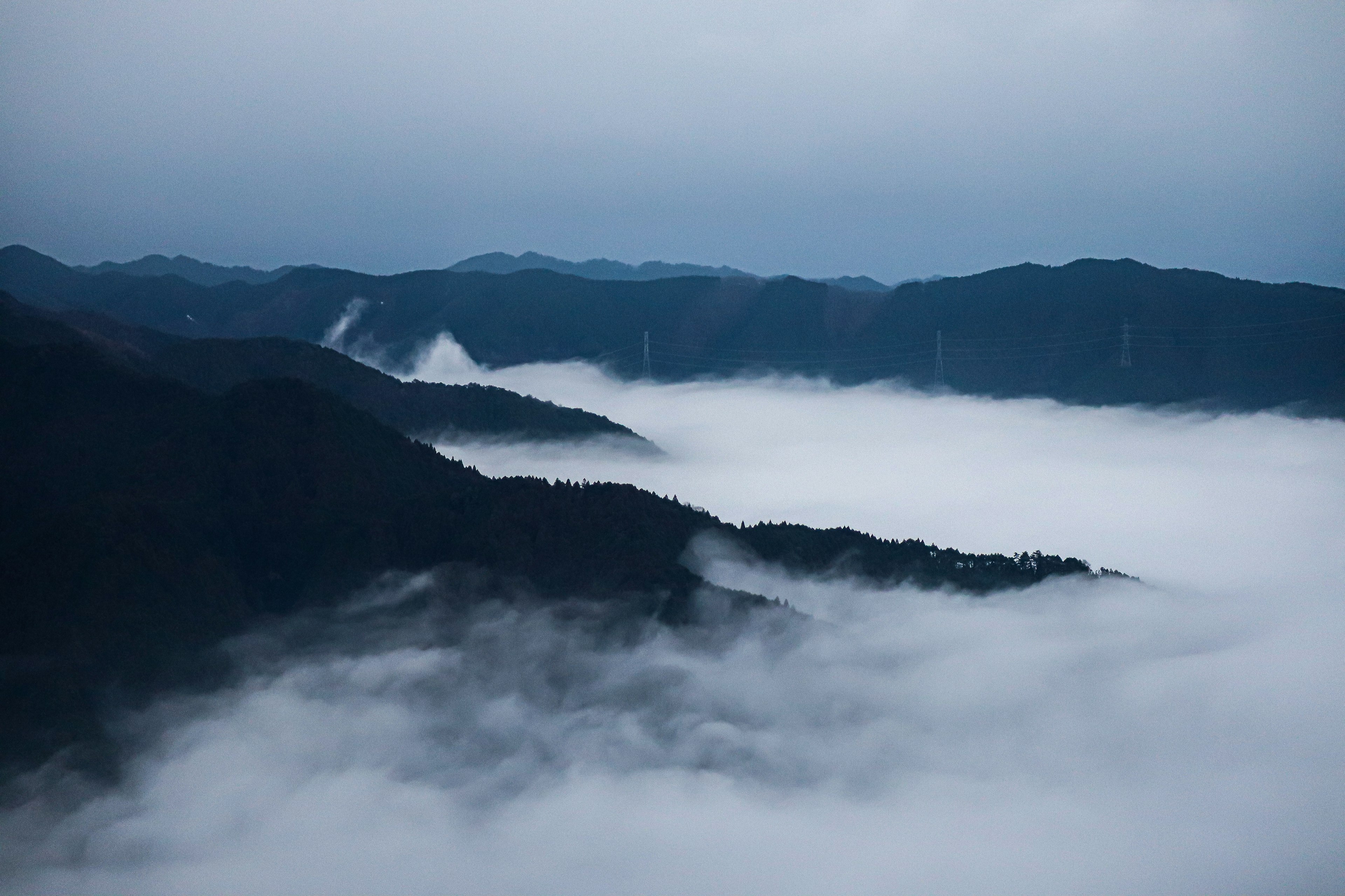 Berglandschaft, die im Nebel liegt, mit einem ruhigen blauen Himmel