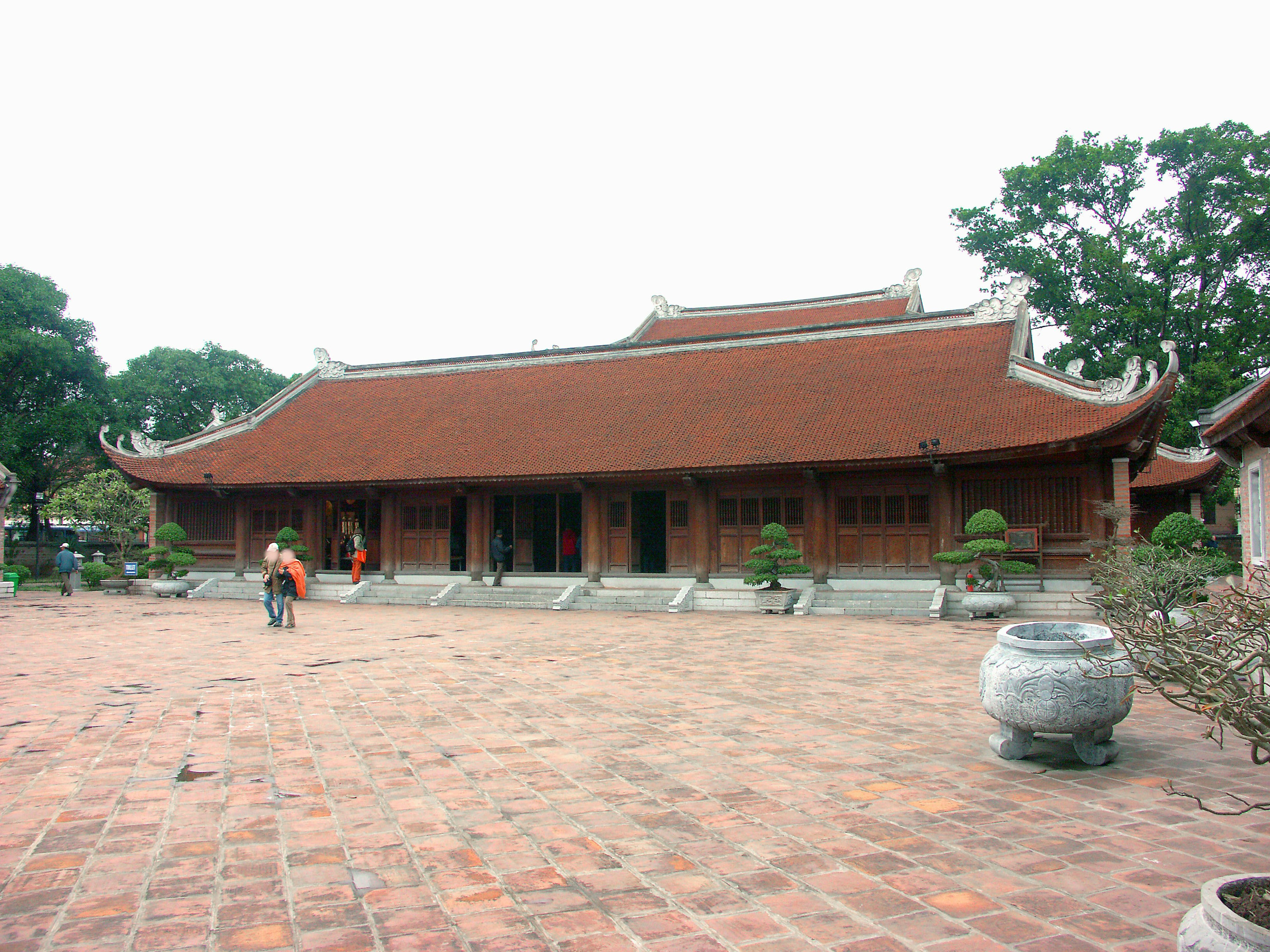 Un edificio de templo histórico con un techo rojo y un amplio patio