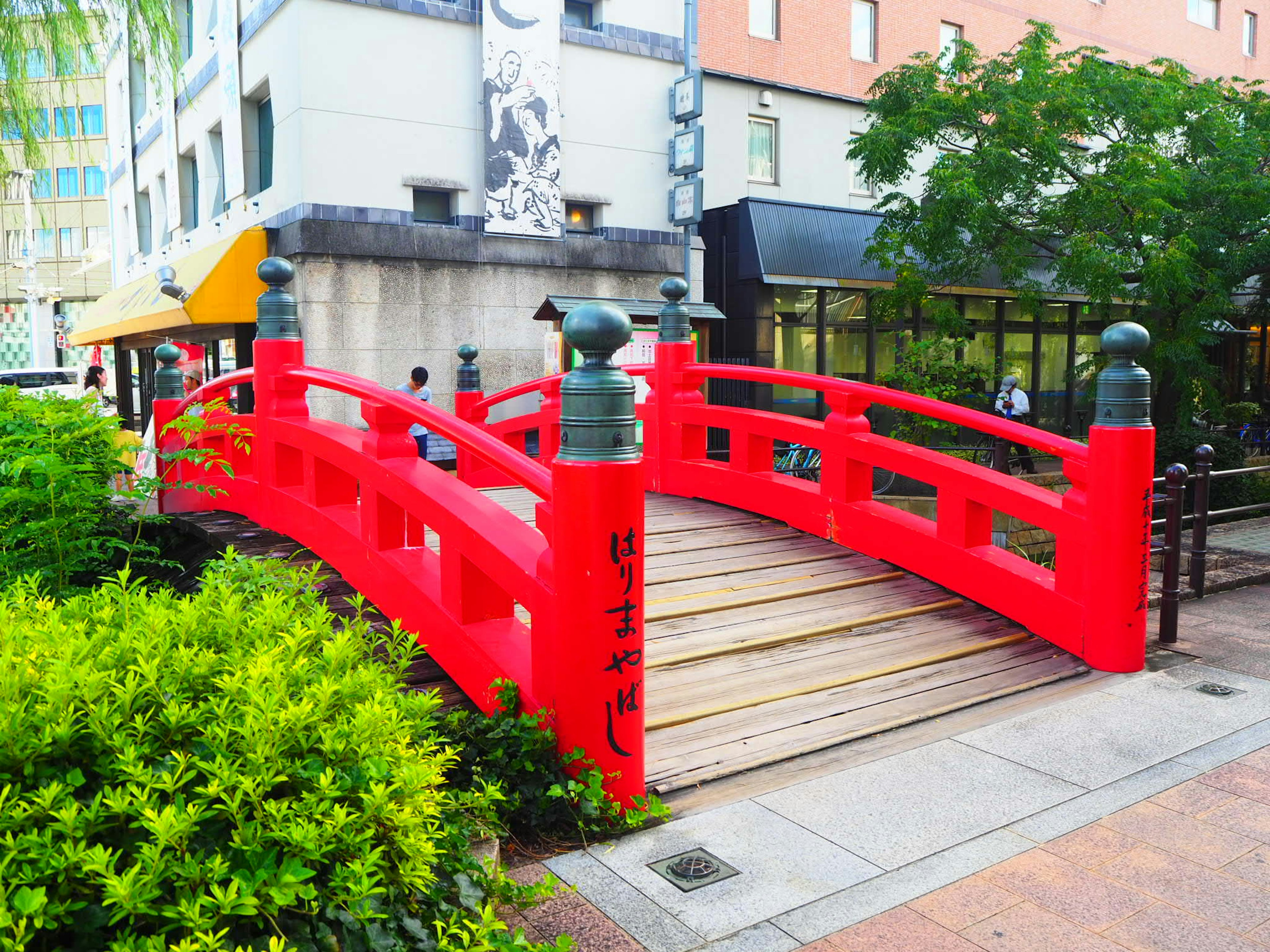 Red bridge in urban setting surrounded by greenery