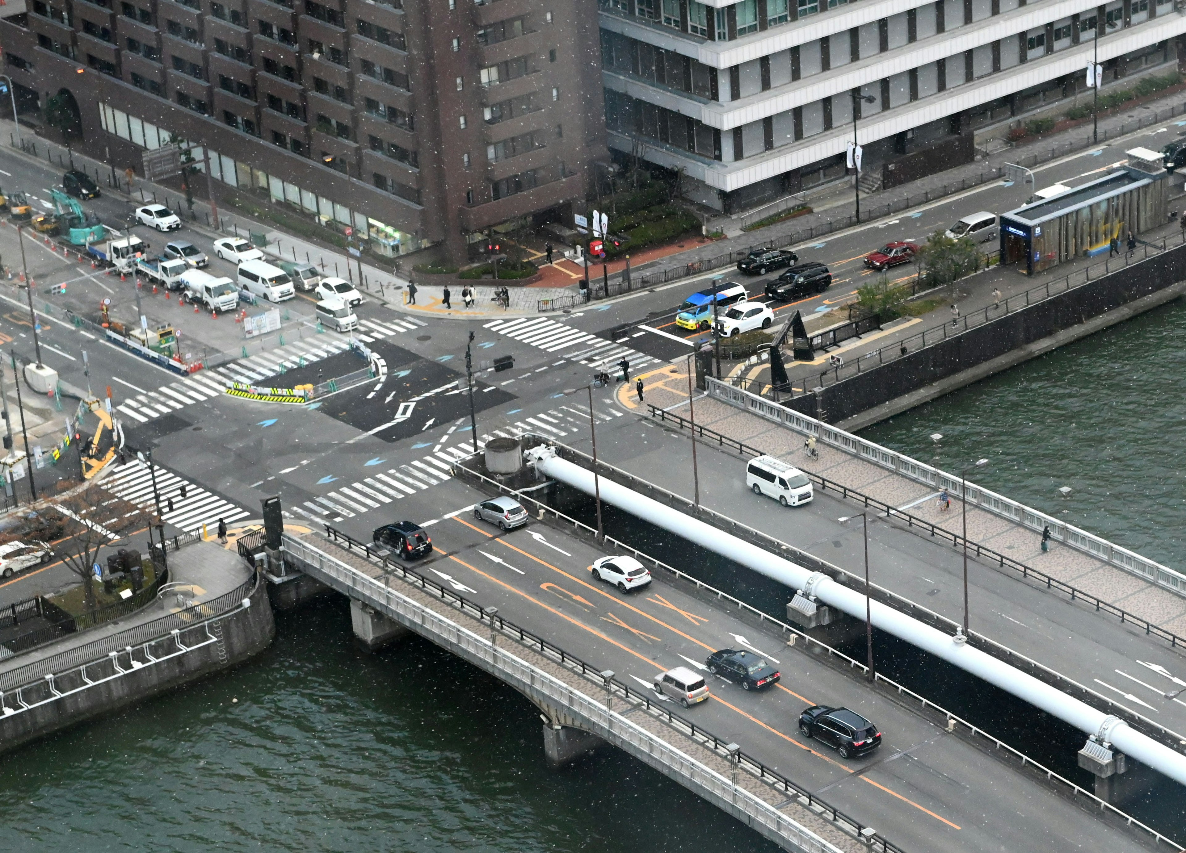 Aerial view of a bridge and cityscape showing traffic intersection