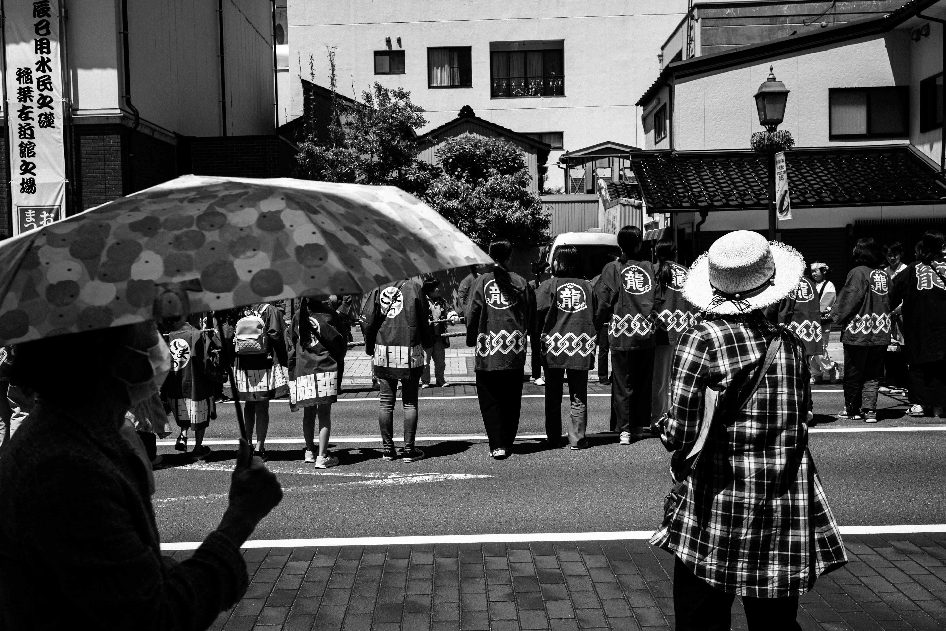 Escena en blanco y negro de personas en atuendos de festival alineadas