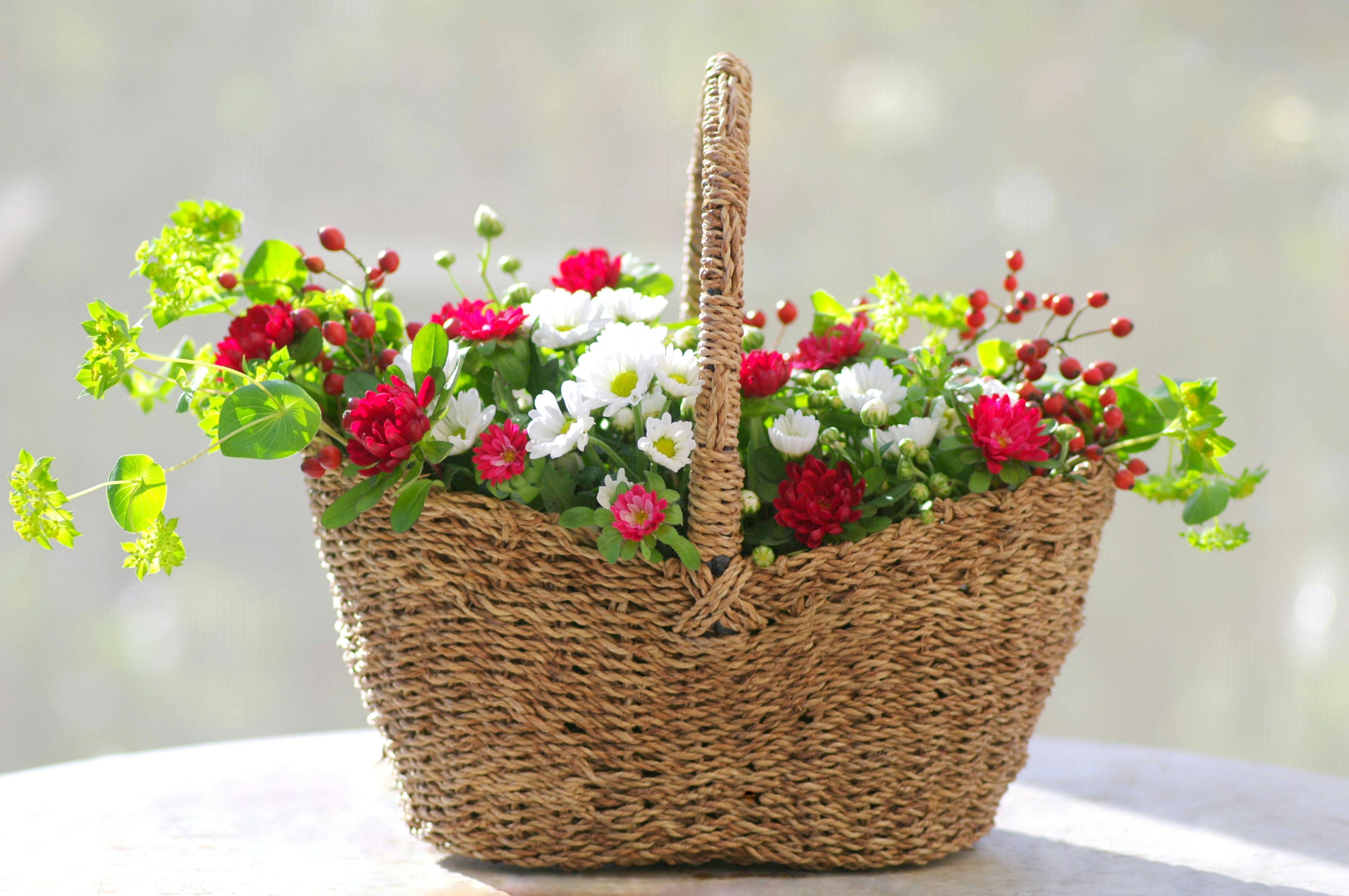 A wicker basket filled with vibrant flowers in various colors