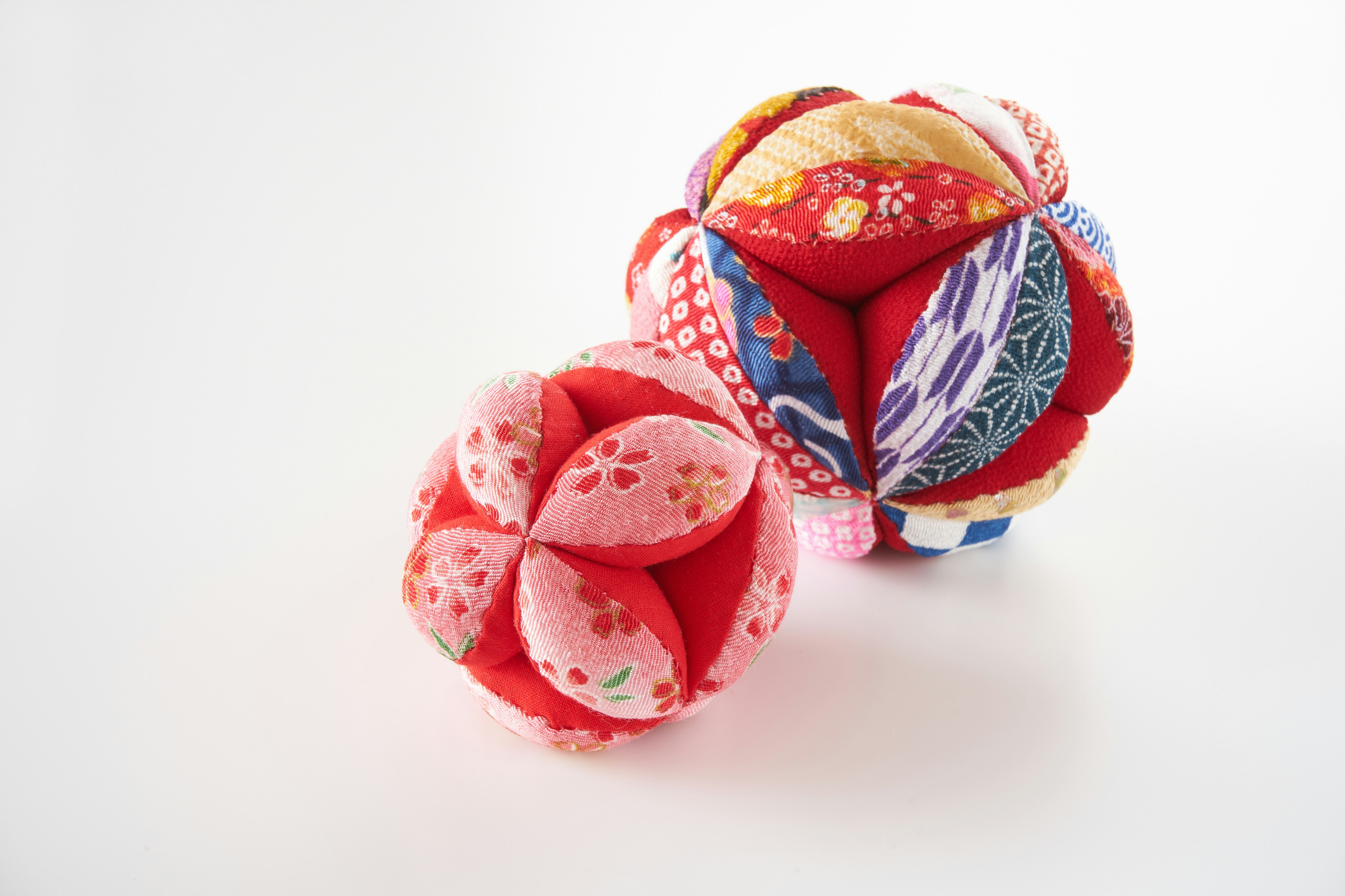 Two beautiful fabric balls in red and pink floral patterns