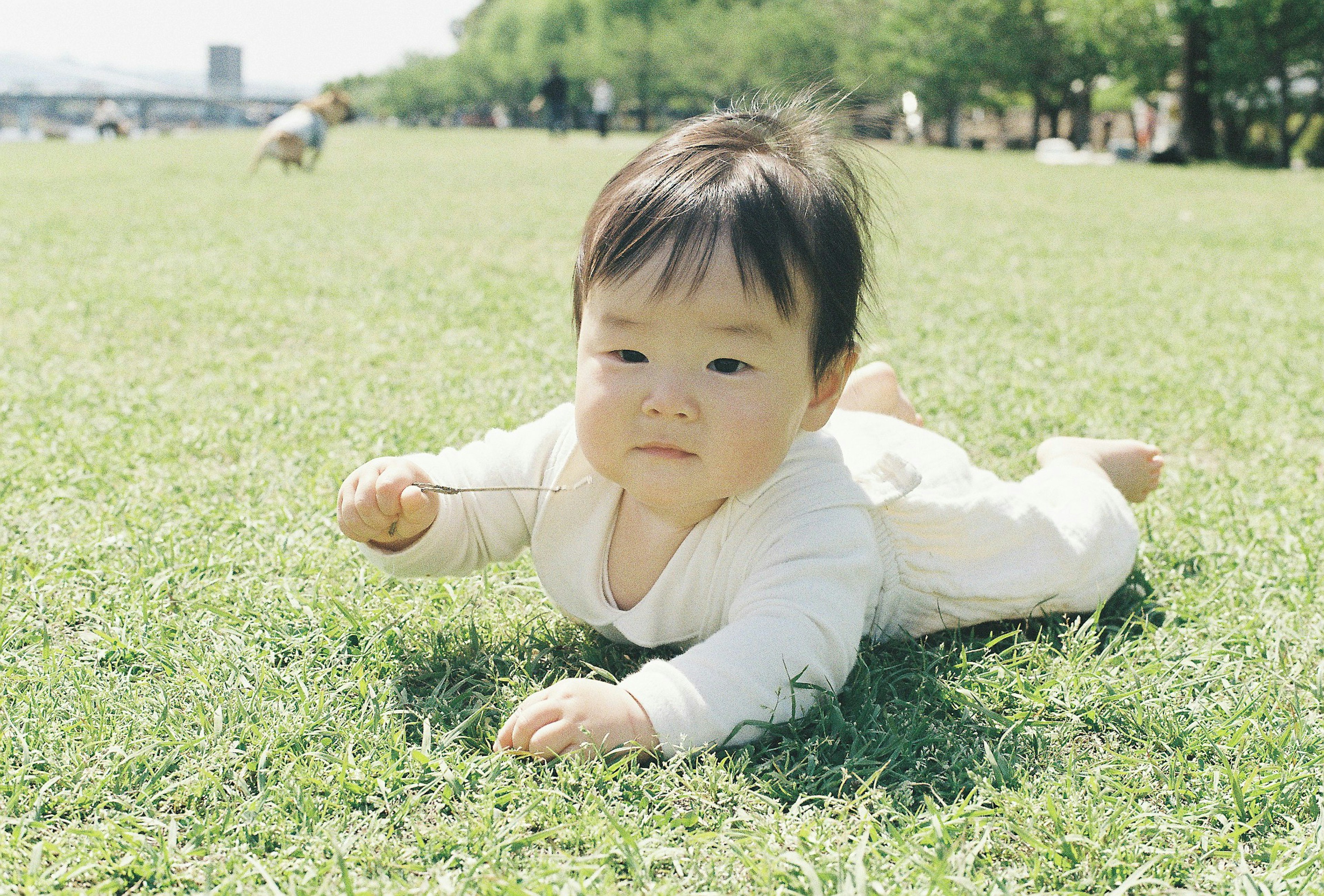 Seorang bayi bermain di rumput di luar