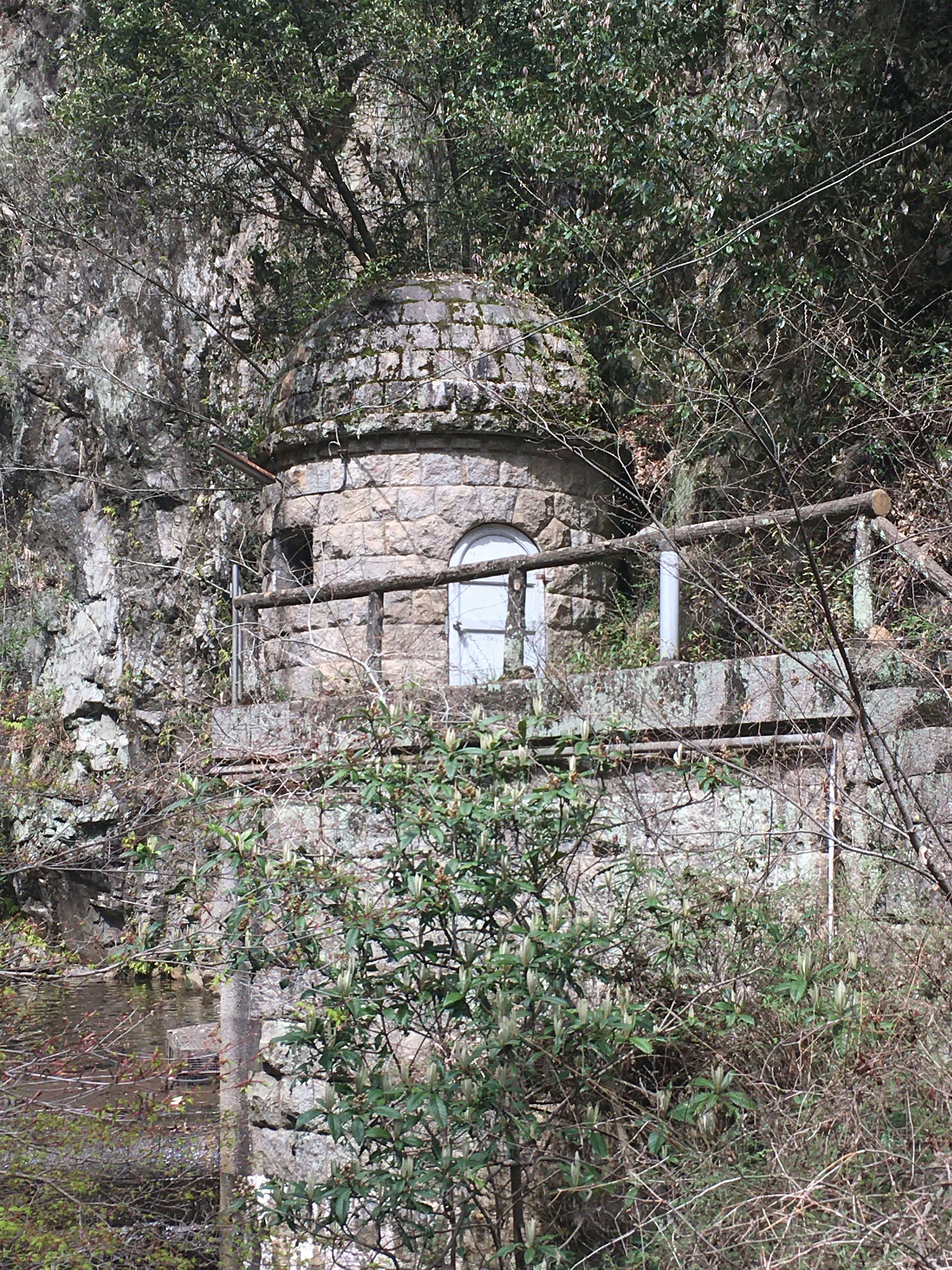 石造りの小屋が木々に囲まれた風景