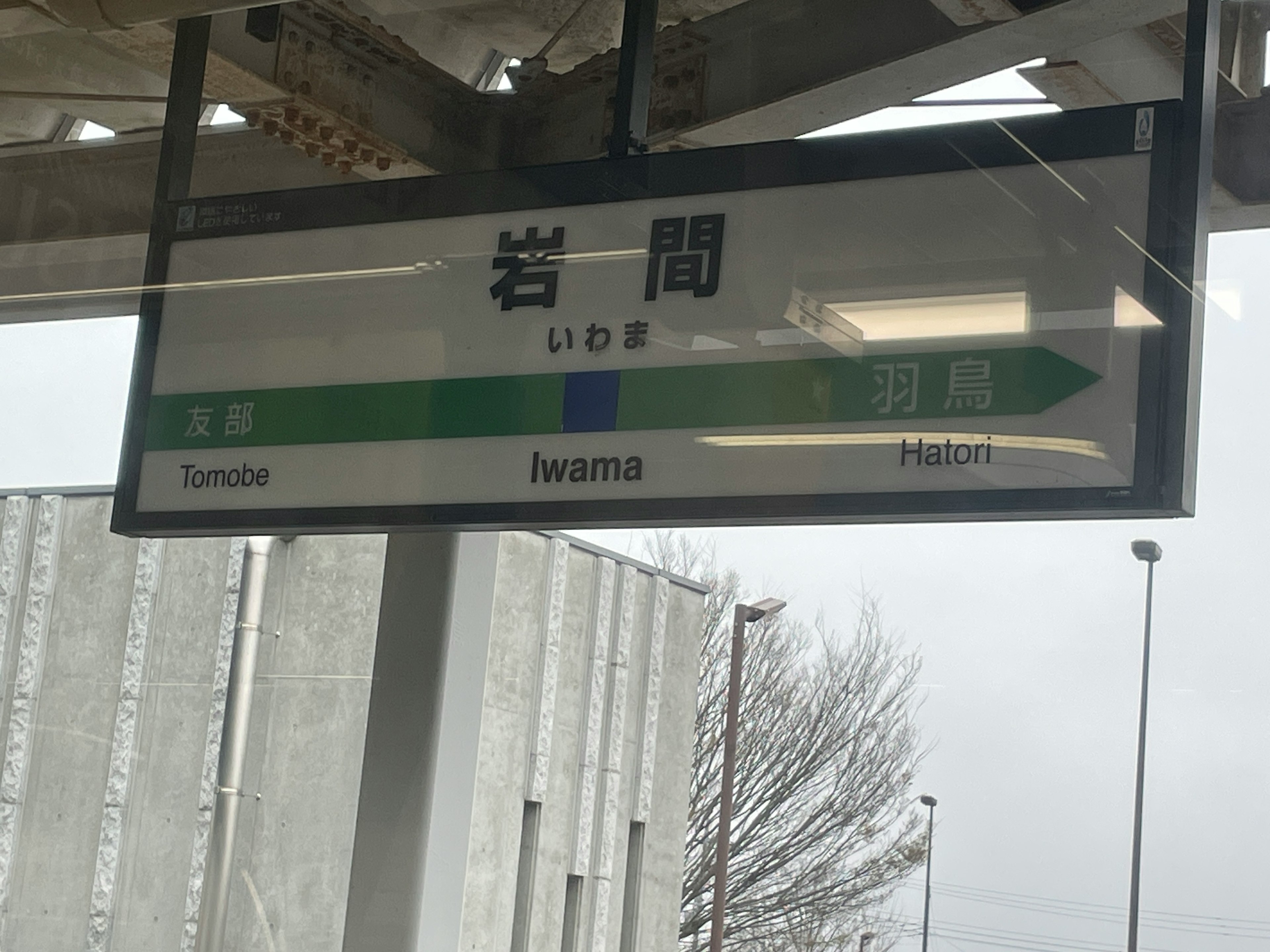 Schild für die Station Iwana mit grünen und blauen Elementen