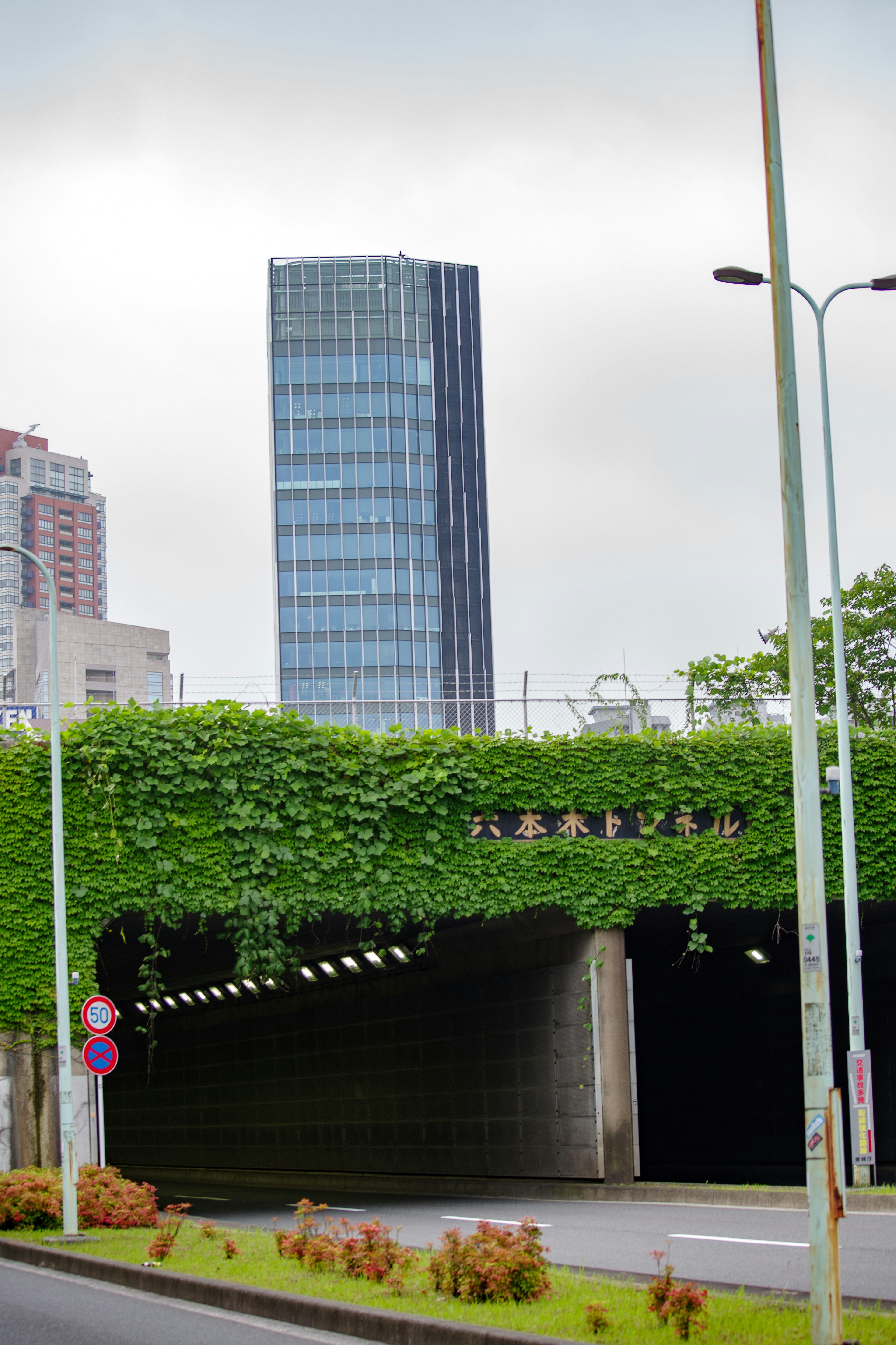 Städtische Szene mit einem hohen Gebäude und einem grünen Tunnel