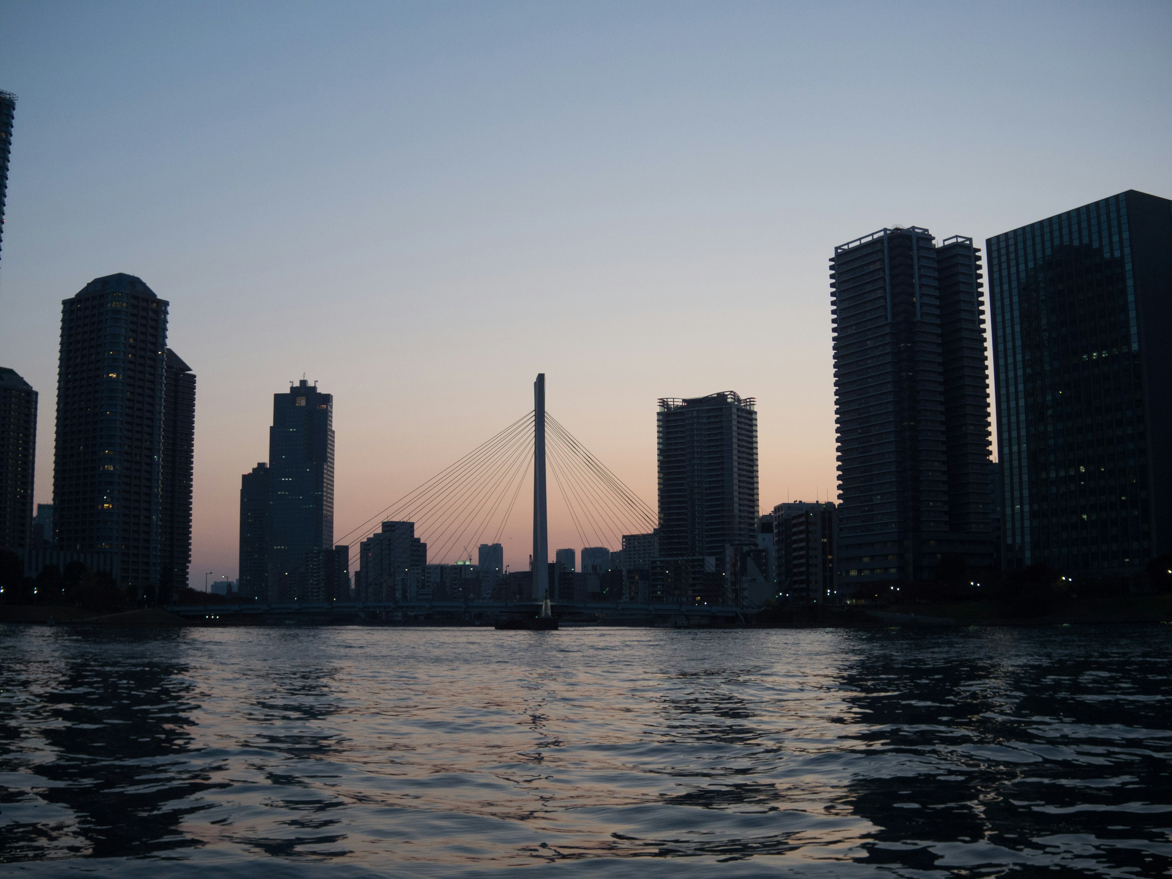 Ligne d'horizon de la ville au crépuscule avec des reflets sur l'eau