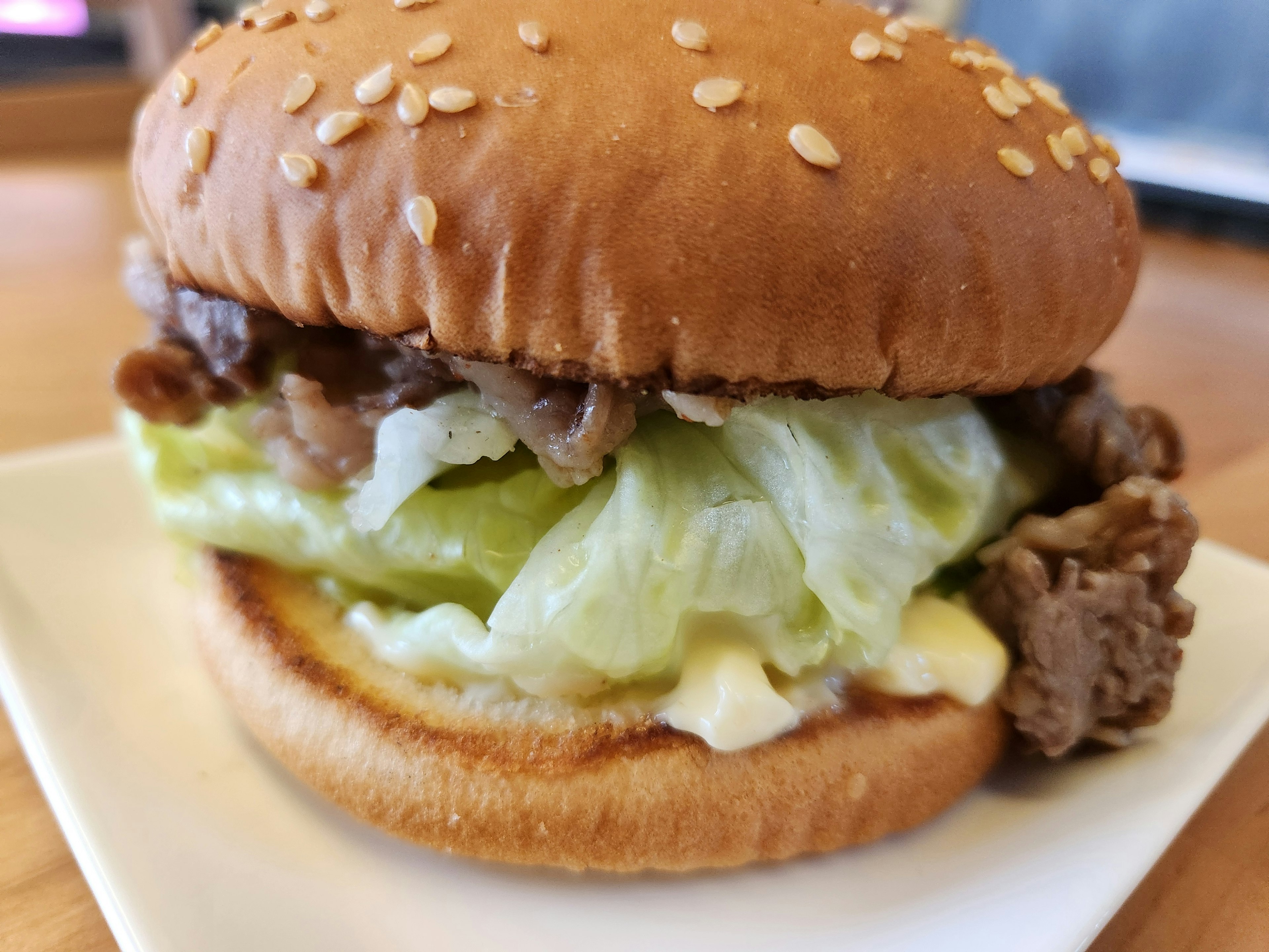 Hamburger mit Sesambrötchen, Salat und Rindfleischfüllung