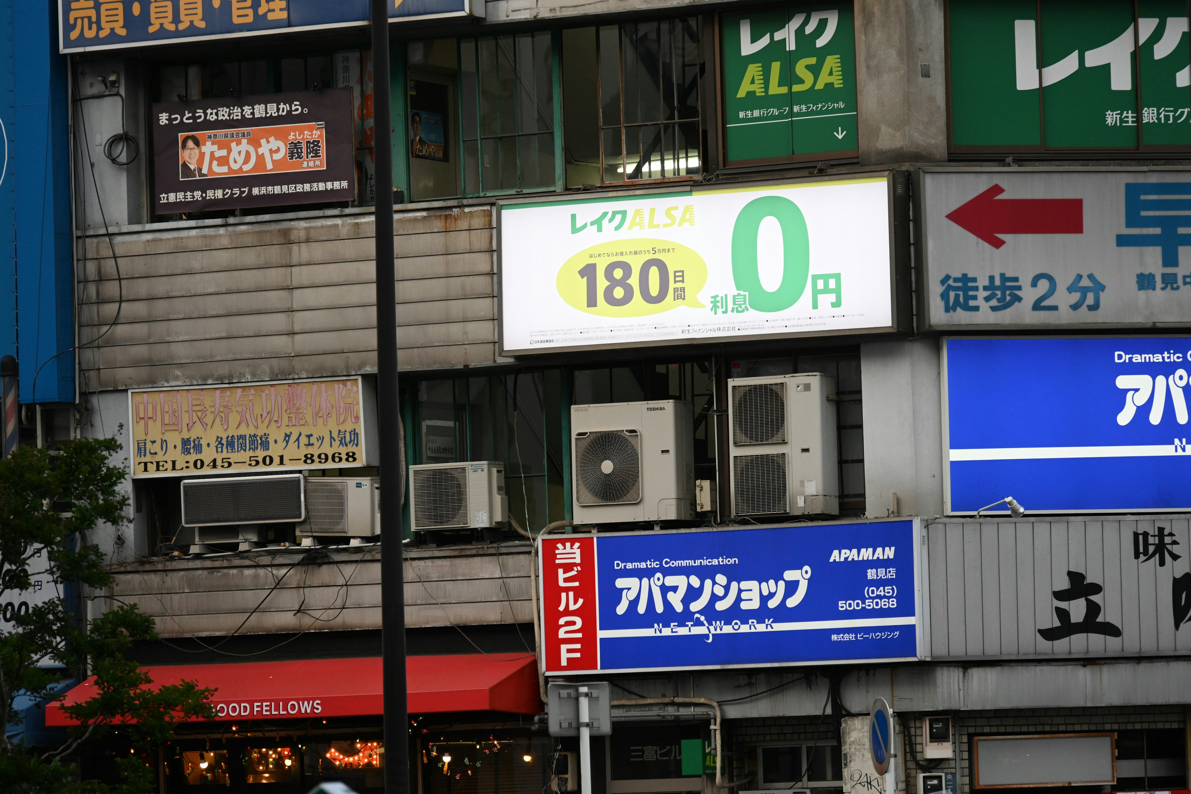 Building facade featuring air conditioning units and various signs