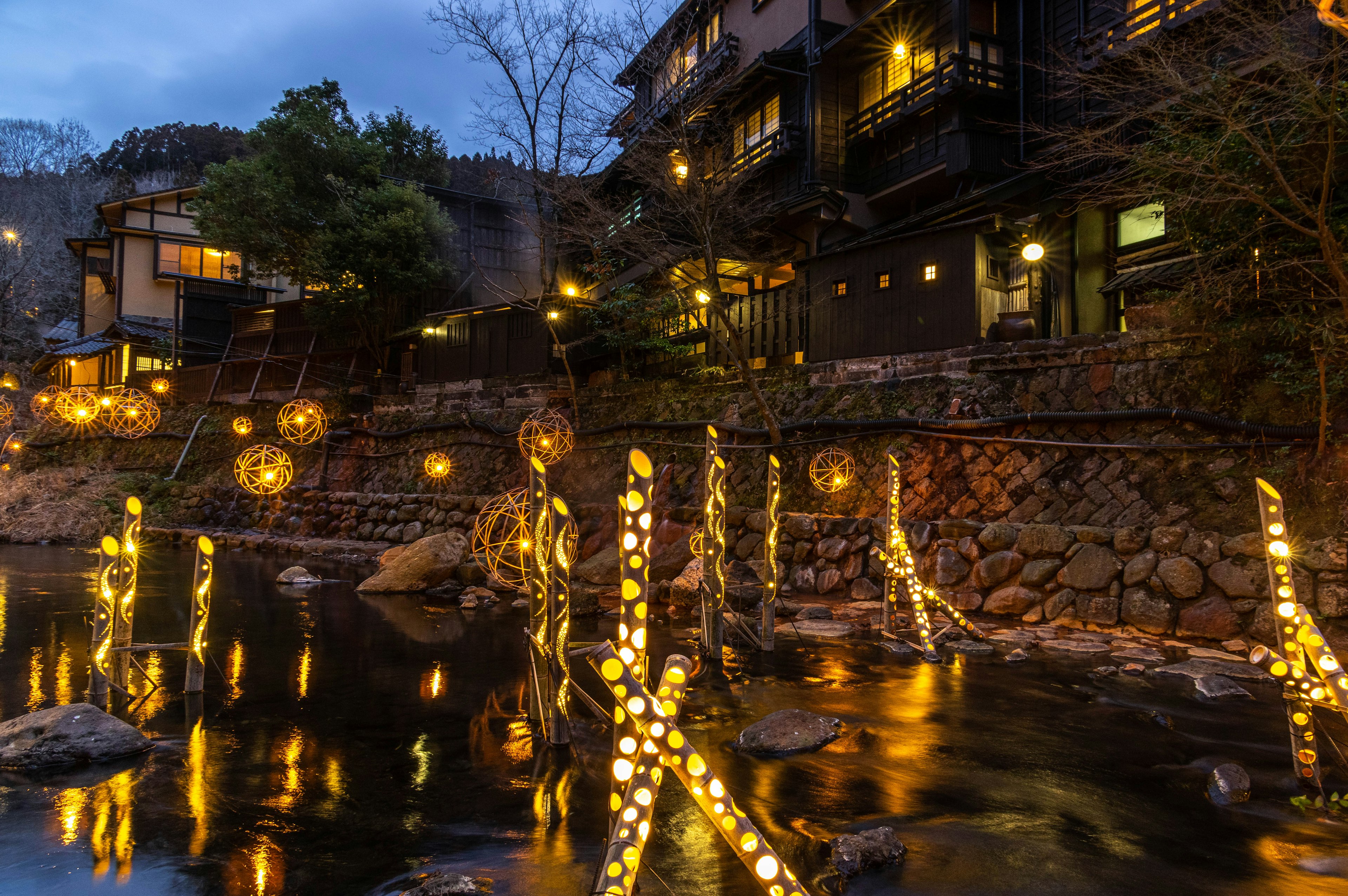 Esferas iluminadas en la orilla de un río en una ciudad termal de noche