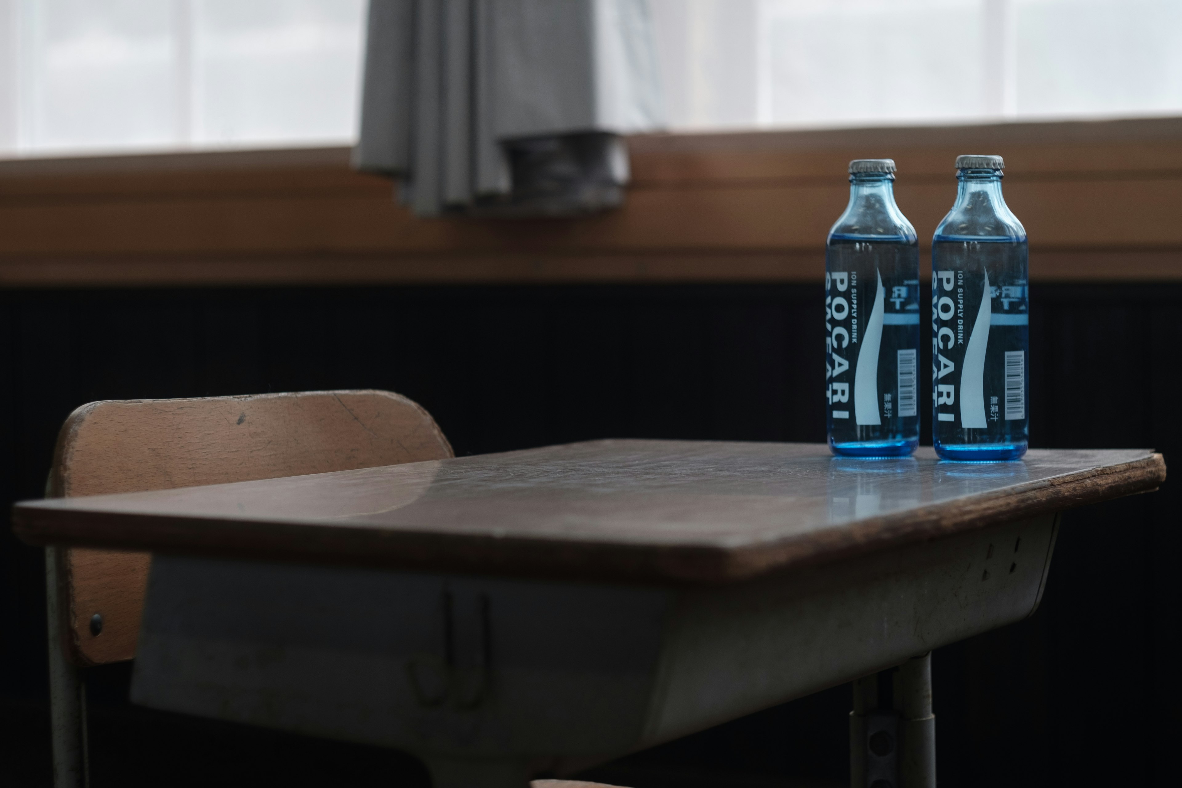 Dos botellas de agua azules sobre un escritorio de madera