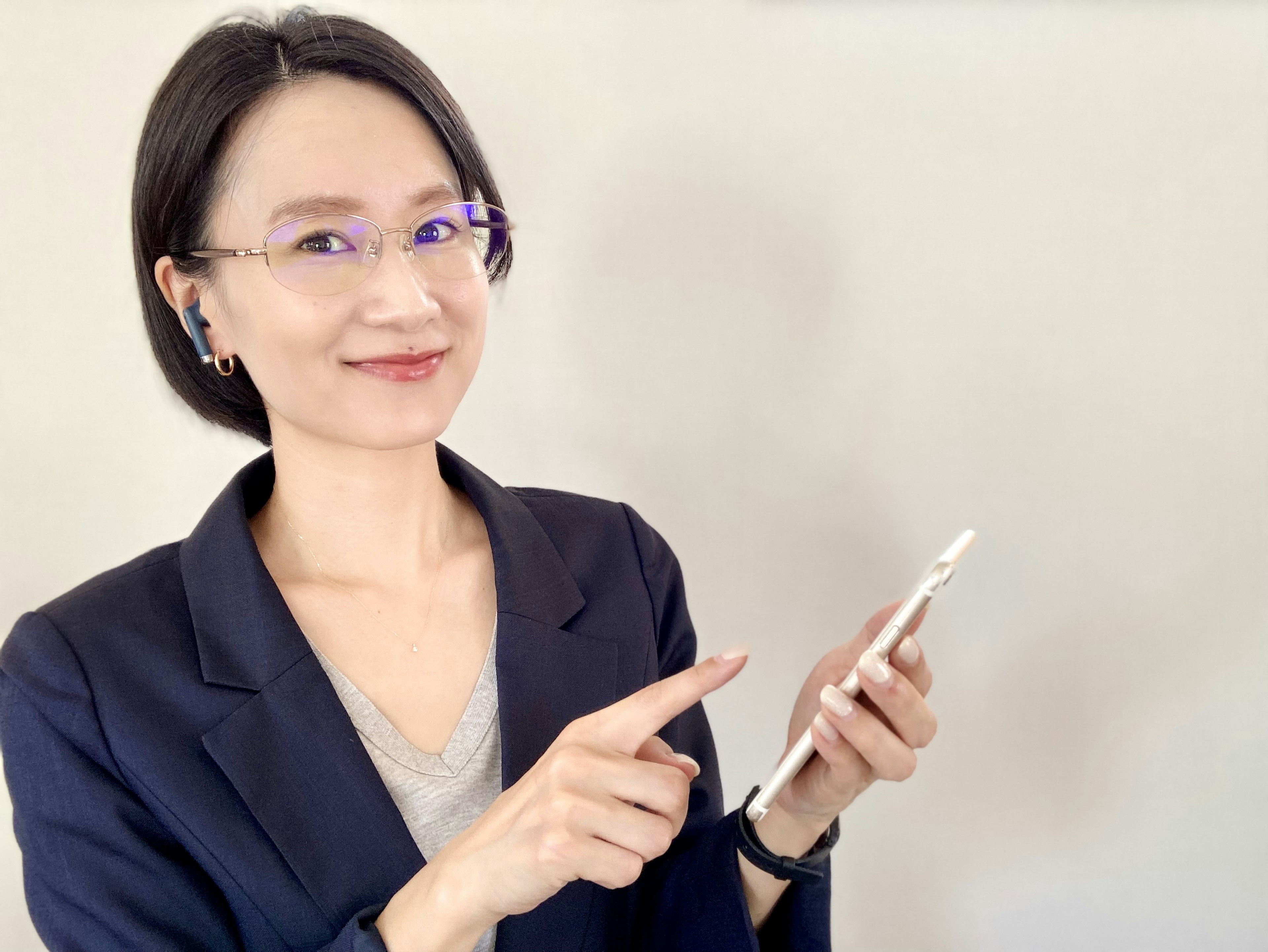 Femme d'affaires souriante pointant un smartphone