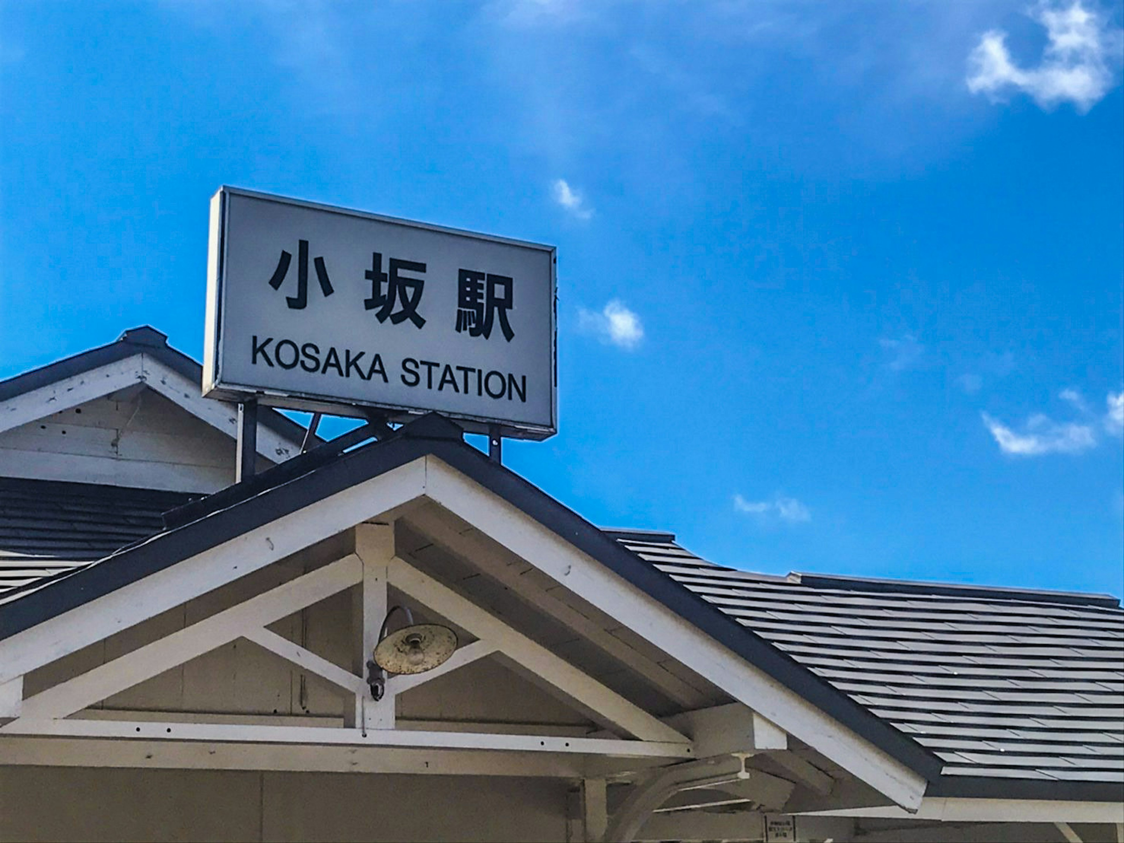 Cartel de la estación Kozaka con cielo azul claro