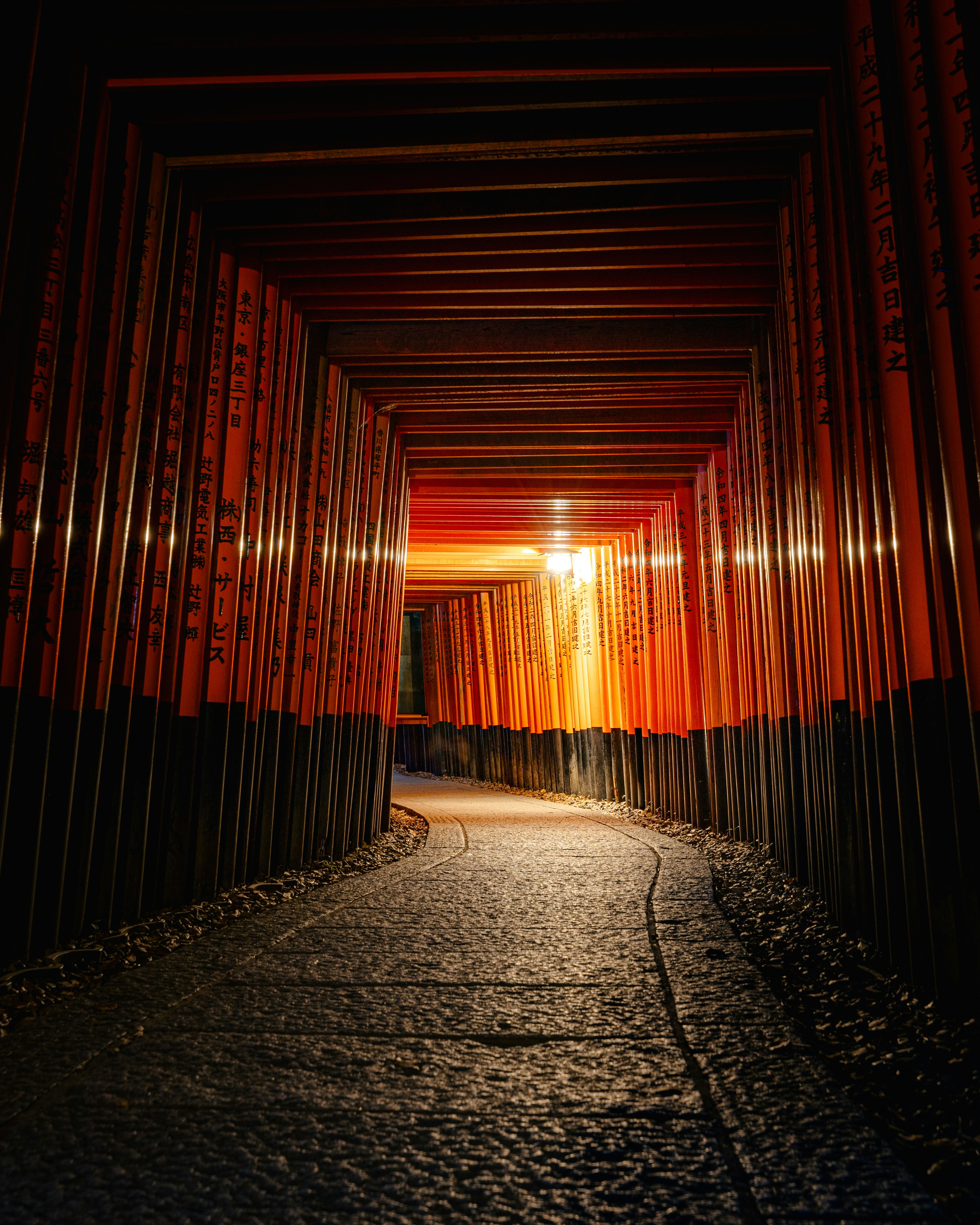 Innenansicht eines dunklen Tunnels mit roten Holz Wänden und einem Pflasterweg